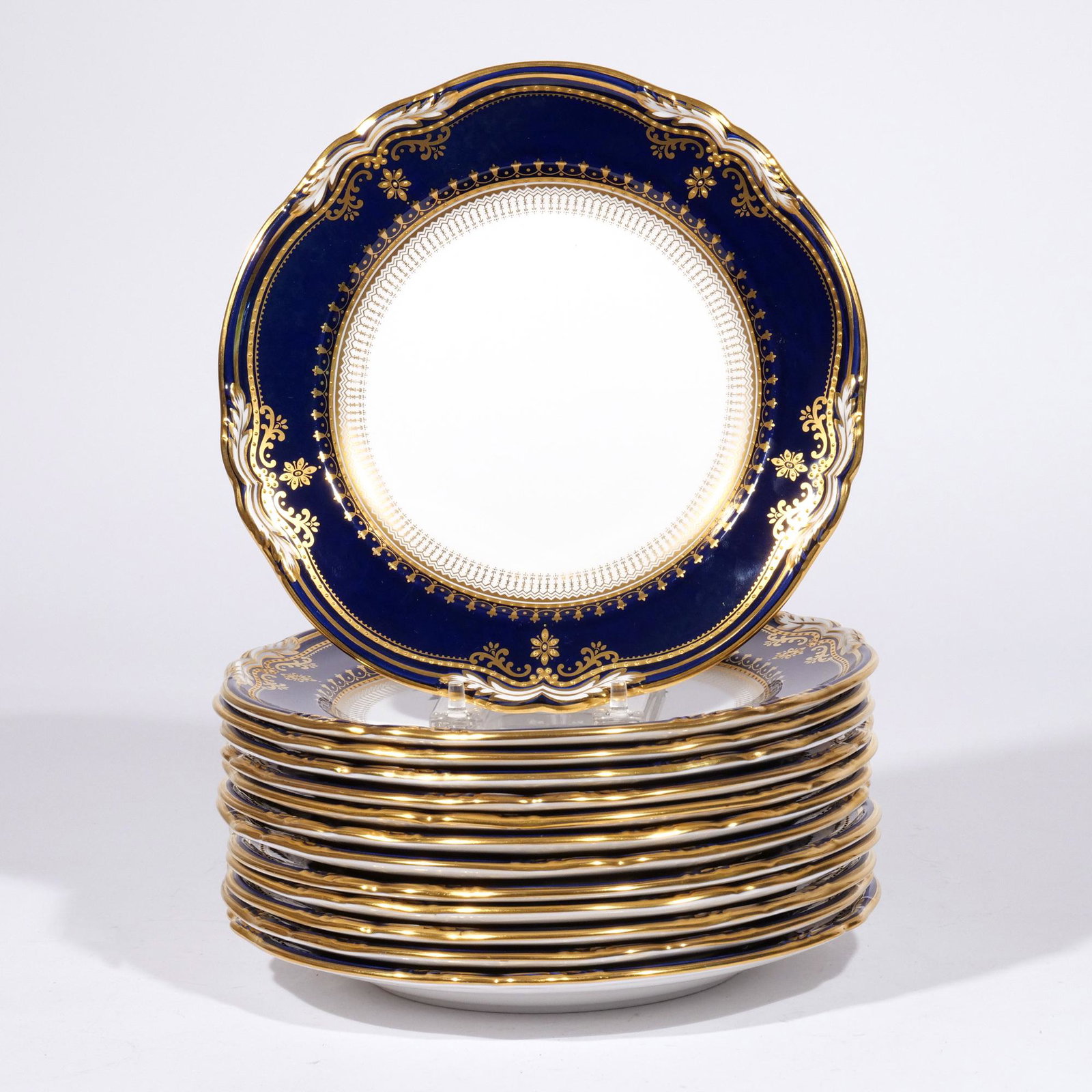 (13pc) SET COPELAND DESSERT PLATES: White centers with cobalt and gilt decorated rims, the bottoms marked, "Spode / Endland Bone China / R8950 / Lancaster / From a Spode Design c. 1889" dia. 9 in. Provenance: Descended through a Greenwi