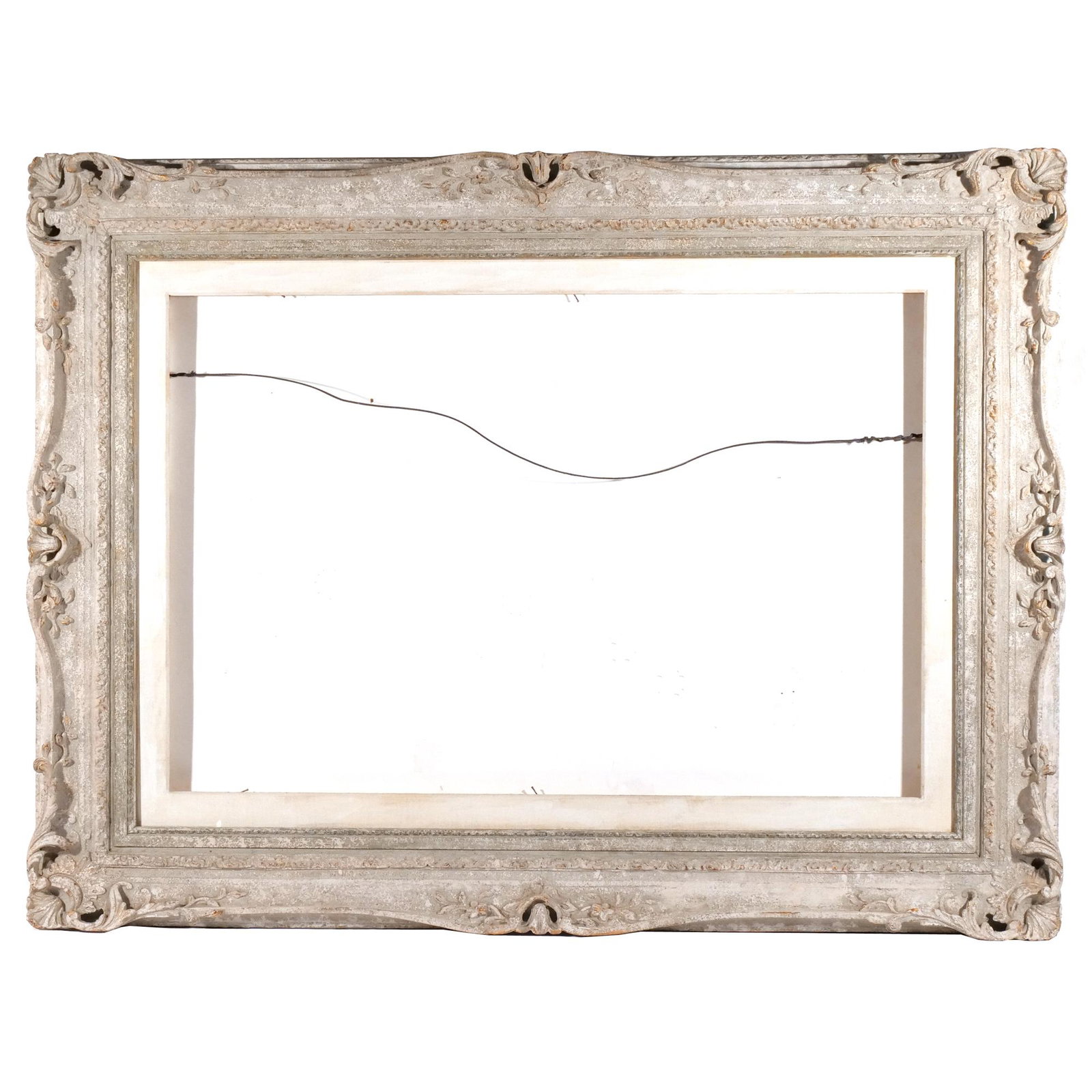 BAROQUE CARVED FRAME: Washed grey paint with scroll carved decorations in high releif; insert opening 27-1/2 x 39-1/2 in; with wood/ mat insert opening 24-1/2 x 36-1/2 in. h. 37 w. 49 in. Provenance: Deaccessioned from a M