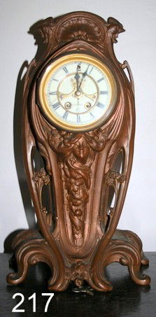 217) GEORGES VAN DE VOORDE ART NOUVEAU BRONZED MANTLE: CLOCK, TIME & STRIKE, MOVEMENT MKD.: ---CLOCK CO. USA, CRESTED BY 2 BACK TO BACK ROASTERS, CLOCK FACE MOUNTED OVER FEMALE HEAD, H.16"