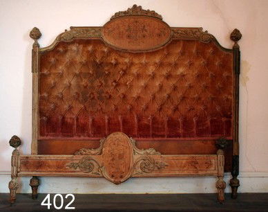 402) LOUIS XVI-STYLE CARVED & INLAID BEDSTEAD: HEADBOARD CRESTED BY CVD. FLOWERHEADS OVER OVAL MEDALLION W/INLAID FLOWERS IN CONTRASTING WOODS, OVER TUFTED UPHOLSTERY, H. 53", W. 57", L. 79", DMGD.& CRUDE REPAIR AT JUNCTION OF SIDE RAIL & FOOT BOA