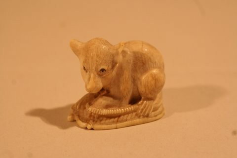 ANTIQUE CARVED IVORY NETSUKE OF MOUSE ON PILLOW: W/ENTWINED TAIL,SGD., COND.: 1-EAR W/MINUTE FLAKES AND MINOR HAIRLINES ON BACK, L. 1 ½"PROV.: GEORGE SARTON & ELEANOR MARBLE (ELWES) SARTON COLL.