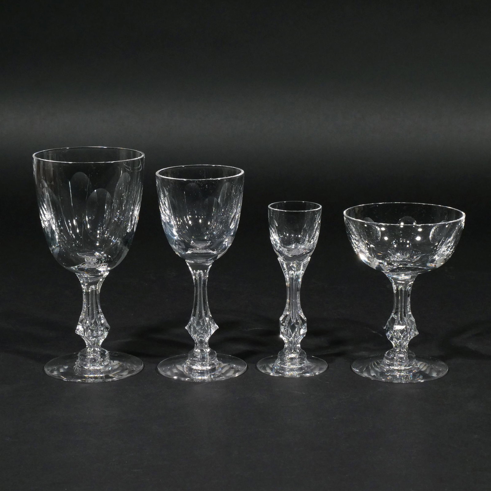 (32pc) CUT CRYSTAL GLASSES: Having blown and cut bowls attached to molded glass stems on blown feet; comprising 12 wine glasses (7 in.) 10 sherry, 5 champagne coupes, and 5 cordials Provenance: Descended through an Armonk, NY fa