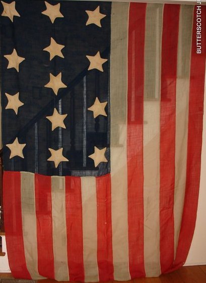 13 STAR FLAG, 70" X 130", W/SOME: REPAIRS & DMG., ALL HAND STICTHED, BY REPUTE: DISPLAYED AT KENNEBUNKPORT, MAINE DURING THE CENTENNIAL CELEBRATION OF THE WAR OF INDEPENDENCE, 1876, IT RESEMBLES A NAVAL FLAG USED BY THE PRIVATEERS OF 