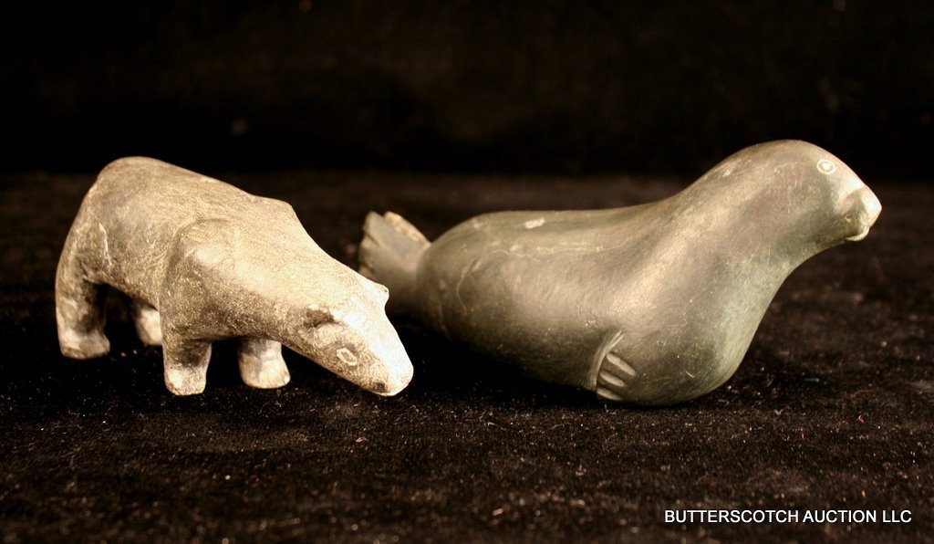 TWO INUIT SOAPSTONE CARVINGS:: A SEAL (7") AND A BEAR (5 ½"); THE BEAR W/ A CHIPPED EAR AND FOOT, BOTH WITH MINOR SCRATCHES