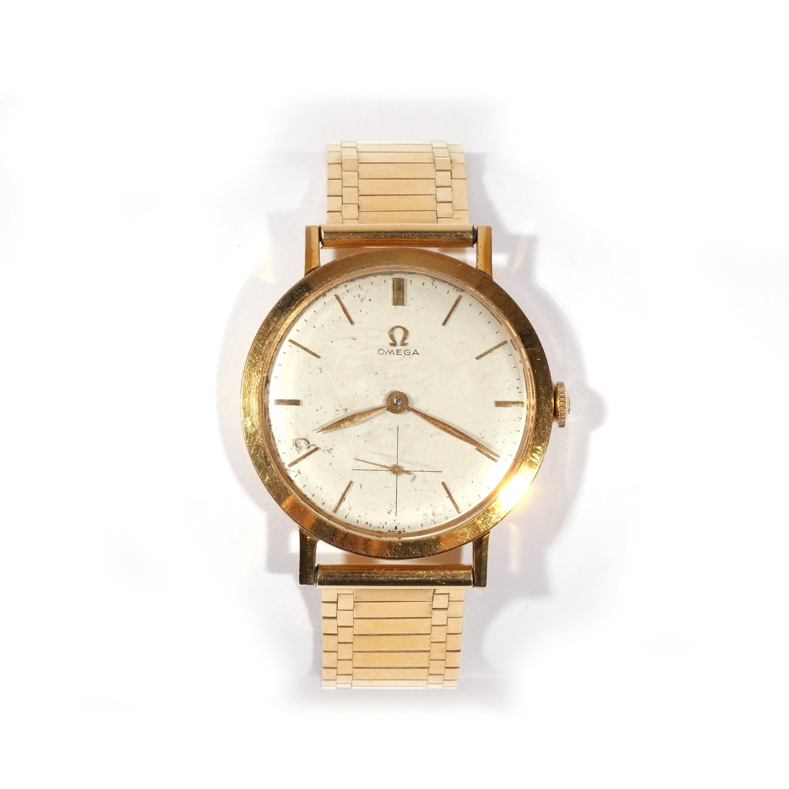 OMEGA 18k GOLD MENS WRISTWATCH: Manual wind, silver face with baton numerals, sub seconds dial, on a fine 14k gold link band, case dia. 37mm, 65.2g, with inscribed dedication dated 1957 Provenance: Descent through a NYC estate
