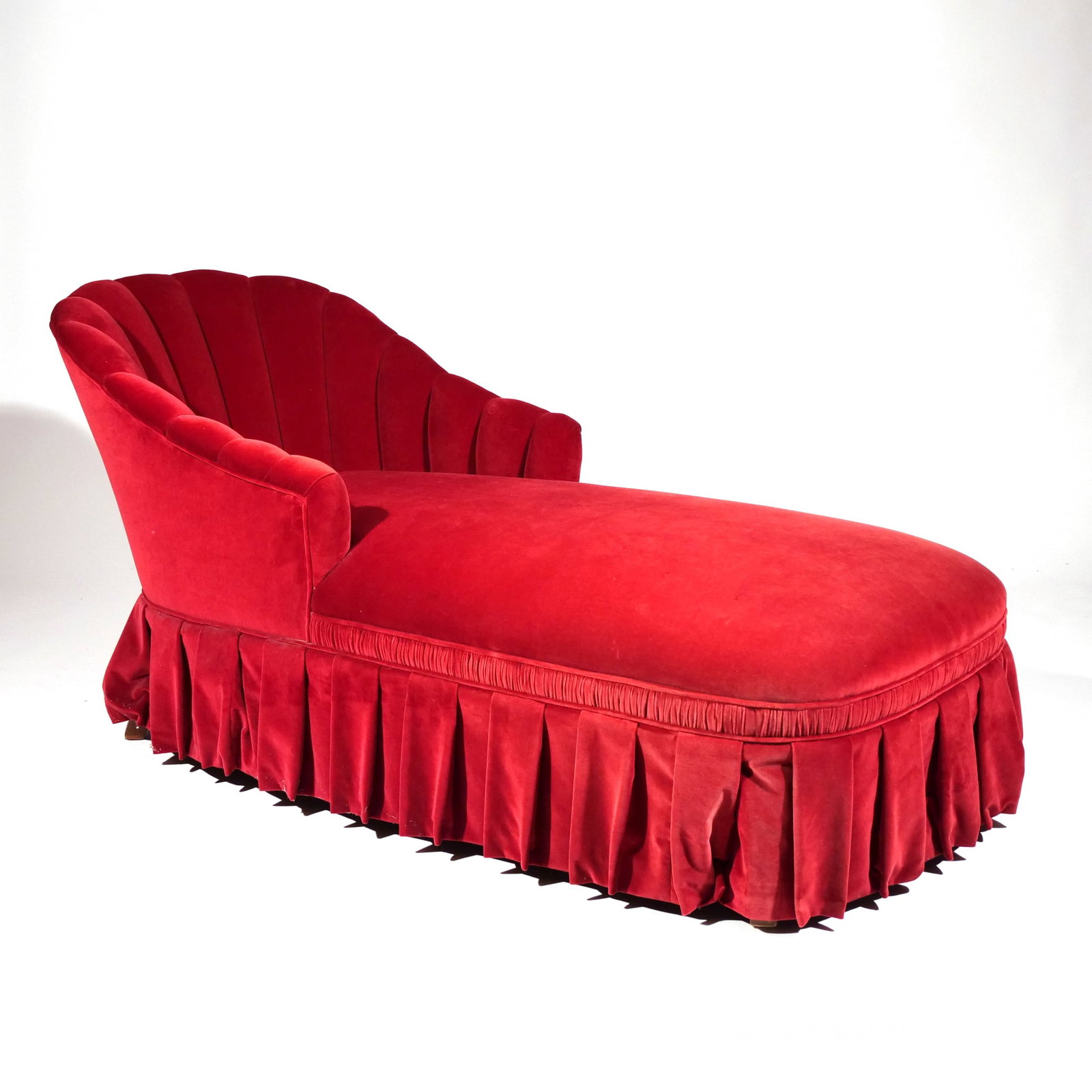 RED CHAISE LOUNGE of SMALL SIZE: Overall upholstery and skirt h. 29 w. 60 d. 26 in. Provenance: A Greenwich, CT estate [In Situ Item] This item will not be on display in our saleroom during our preview period. If you wish to view it 