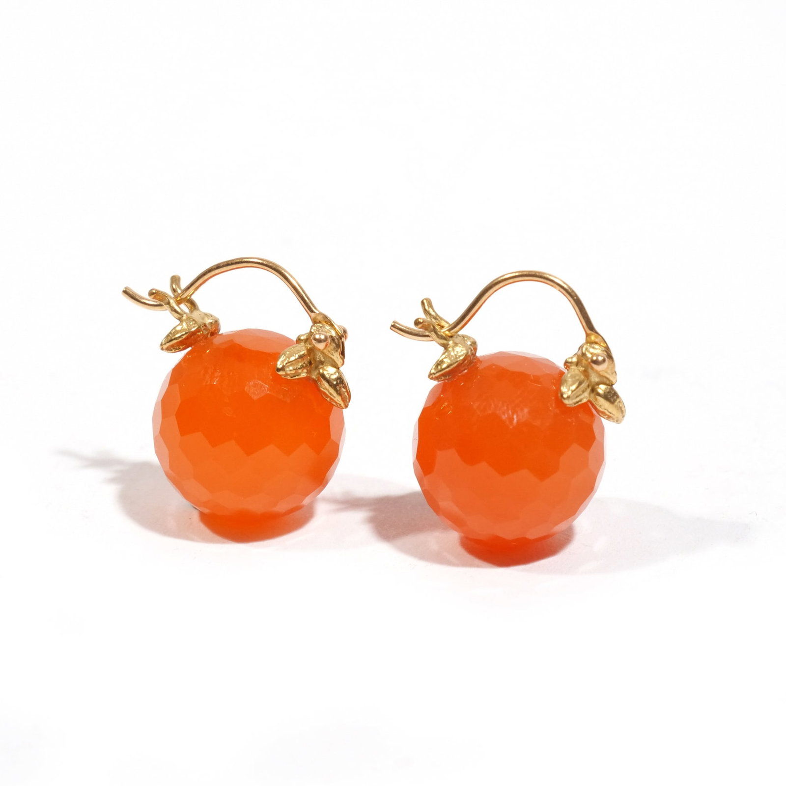 GABRIELLE SANCHEZ 18k & FACETED RONDELLE TANGERINE: Each huggie-style earring having an 11x 13mm faceted rondelle tangerine-hued carnelian gemstone suspended from 18k yellow gold "Flyer"setting; 6.4g h. 3/4 in. Provenance: From a Pound Ridge, NY collec