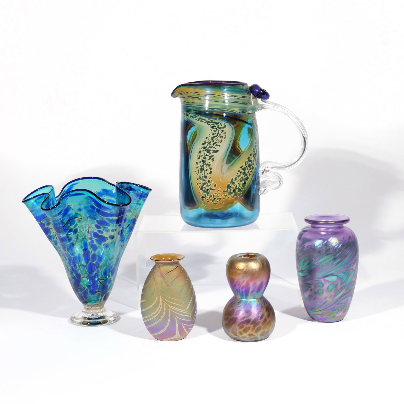 (5pc) ART GLASS: Circa 1980s or later, including a blown glass pitcher, a blown glass linenfold vase, and three misc. lustre vases, most signed indistinctly h. 9 w. 9 in. (pitcher) Provenance: A Scarsdale, NY estate [