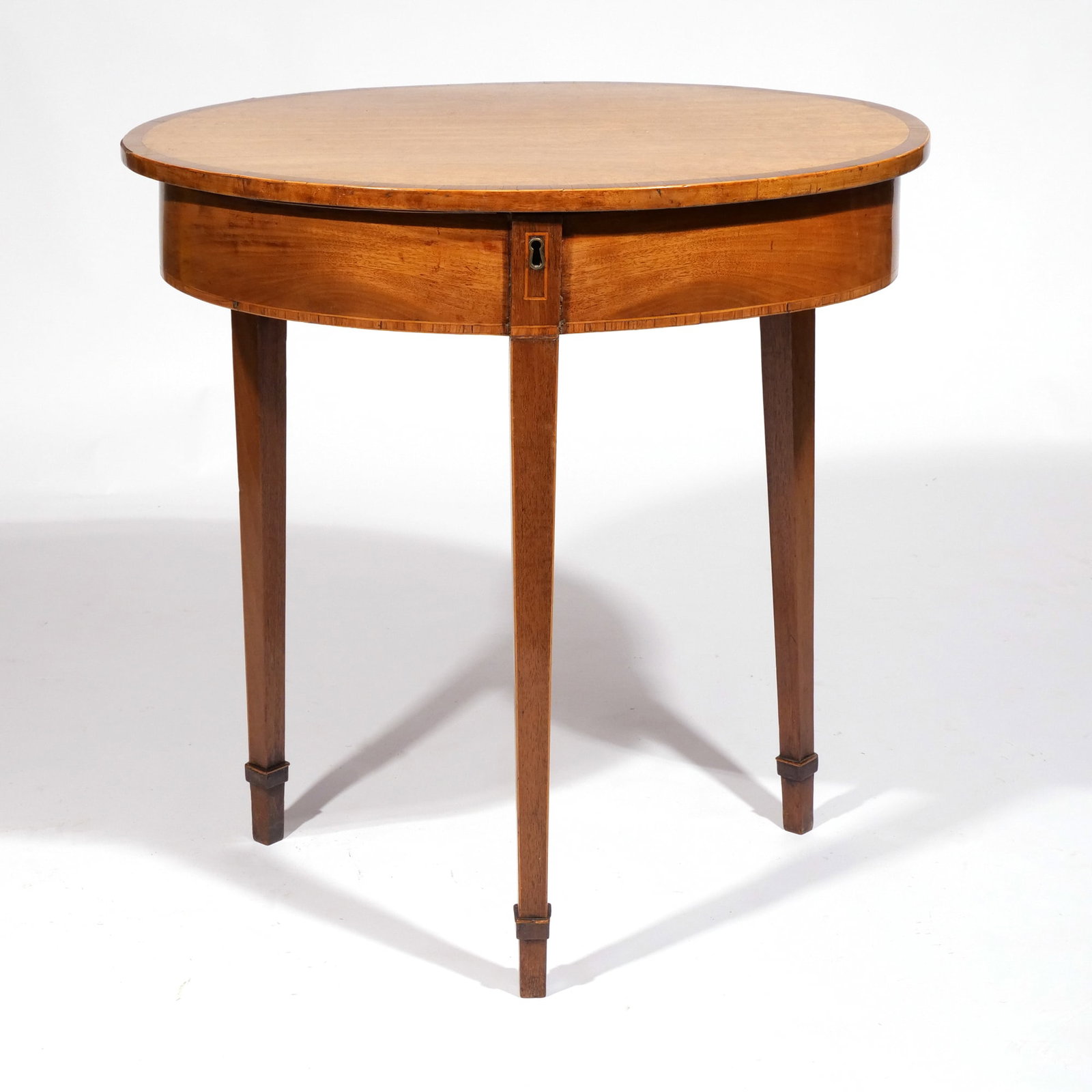 GEORGE III SATINWOOD INLAY TRESTLE TABLE: Possibly Irish, the oval top lifts up to a baize compartment, raised on square tapering legs h. 27-1/2 w. 26-1/2 d. 20-1/2 in. Provenance: By descent through a prominent Westchester family