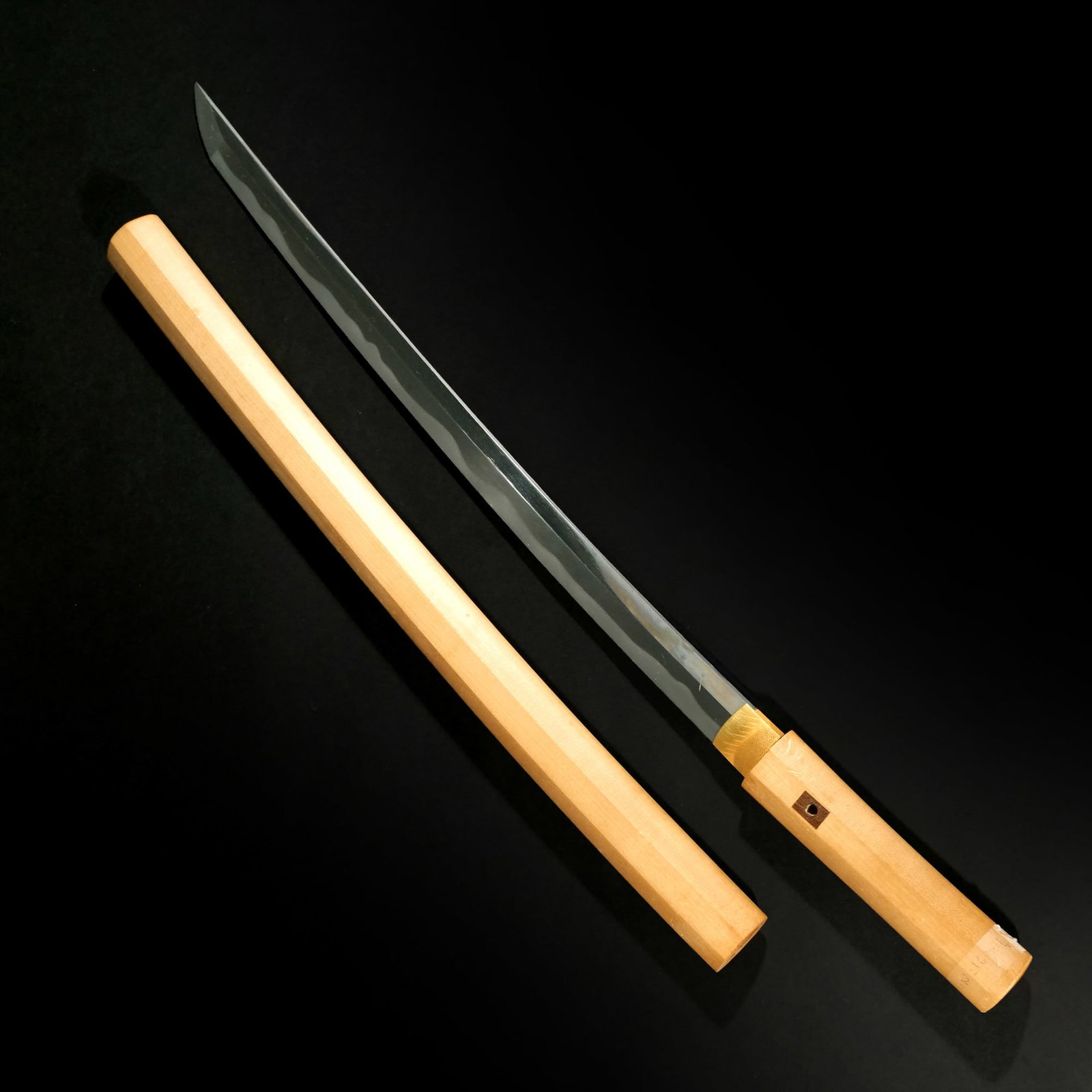 WAKIZASHI BLADE: Unsigned, likely Edo period (1603-1868), hamon (tempering) is notare midare with slight mokume hada (grain), kiri nakago-jiri (tang), in shirasaya (case), cutting edge: appx. 19 in., total length: 25 