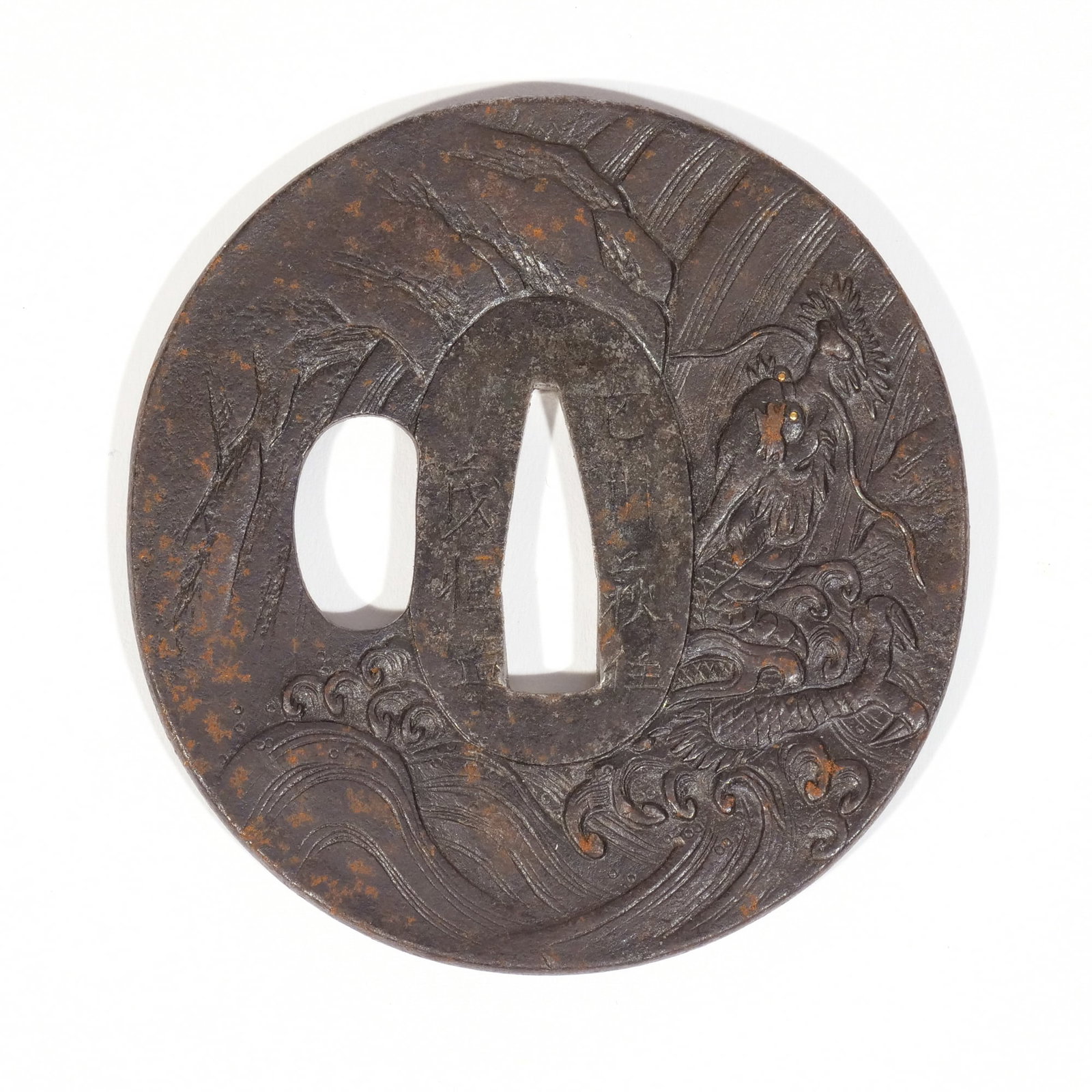 HAGI TSUBA: Edo period (19th century), signed 'Choshu Hagi ju Shigetsune tsukuru' (Made by Shigetsune, resident in Hagi, Choshu), a maru gata tetsu (iron) tsuba with one hitsu, relief decoration with a dragon wit