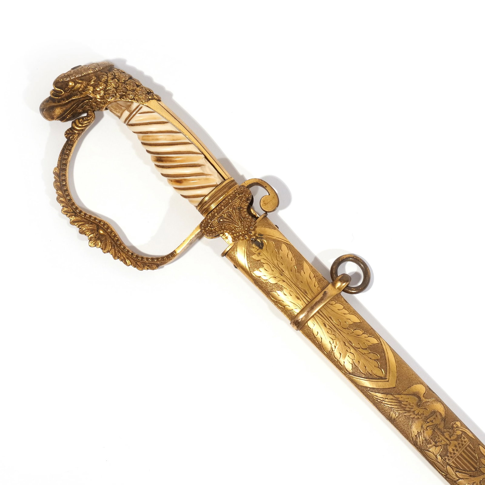 AMERICAN BRASS SWORD BY R. I. BROWNE: Having a carved bone handle, a pommel decorated with an eagle's head, and having a sheath decorated with an eagle, flag and foliage motif, and blade decorated with gilt eagle motif, maker's mark R.I. 