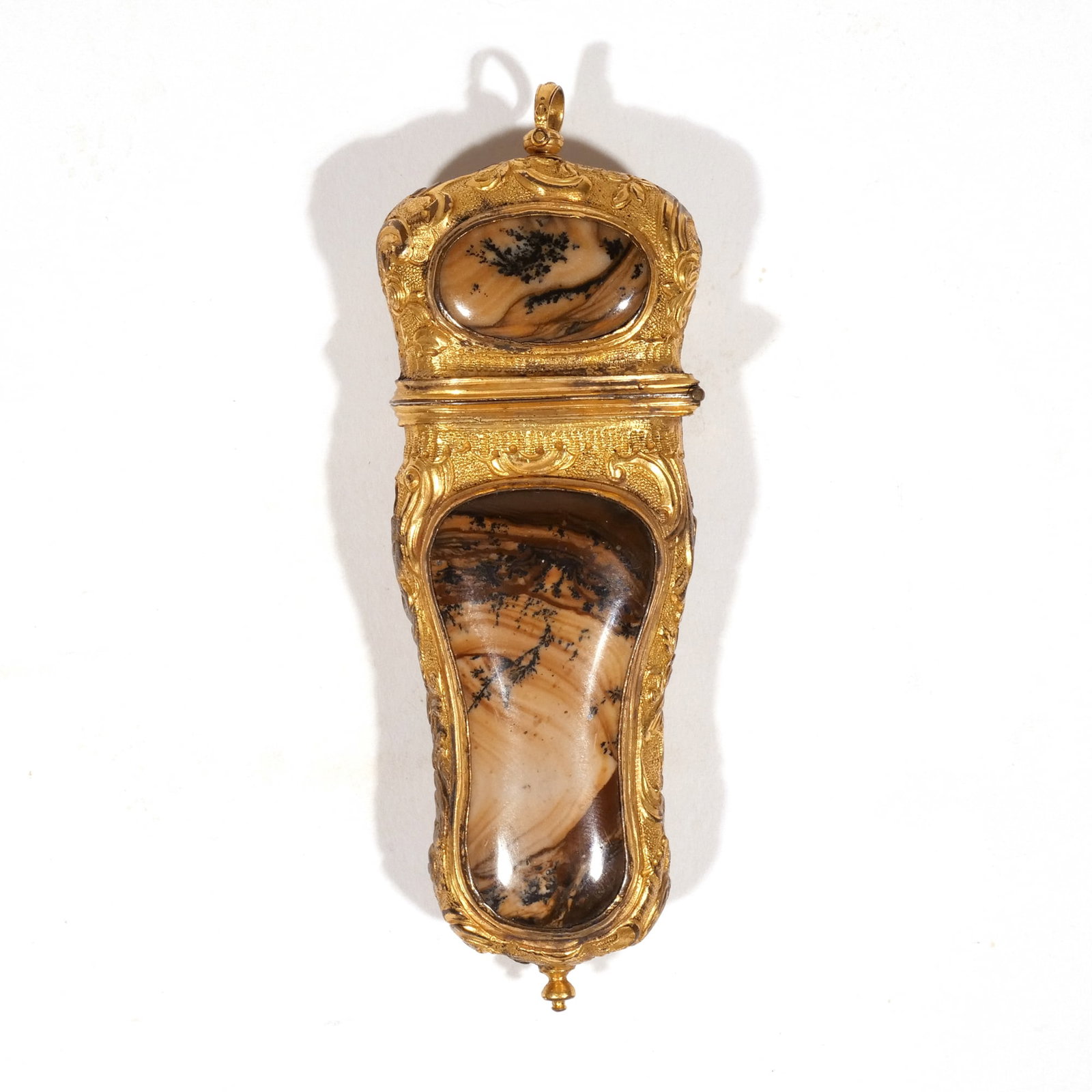 FRENCH GILT-METAL AND HARDSTONE ETUI: Having cartouche form, with hinged lid, the sides chased with flowers, the sides set with mocha agate panels (or other hard stone), with a small gold-tone spoon inside, unmarked h. 4 in. Provenance: T