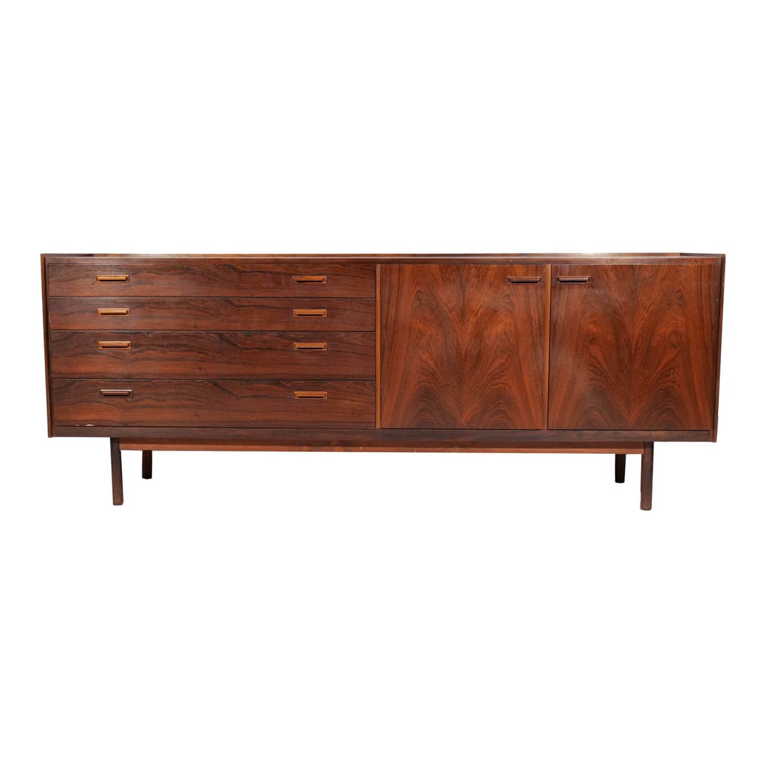 DANISH ROSEWOOD DRESSER: Mid 20th century, with a bank of four graduated drawers to the left of double cabinet doors, with Danish export mark h. 31 w. 81 d. 20 in. Provenance: The Collection of Lynn and Bruce Heckman, noted c