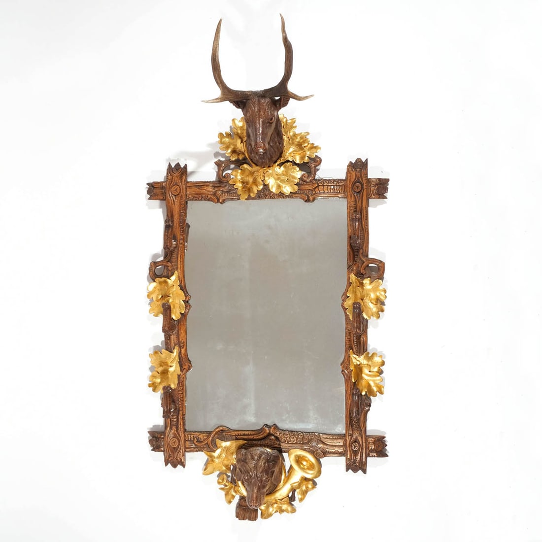 FINE FRENCH / BLACK FOREST CARVED HUNTING RACK: Late 19th / early 20th century, mirrored back, gun or hat rack with stag head above and dog?s head below, gilt oak leaves and hunting horns h. 52 w. 31 d. 20 in. Provenance: Descended through a noted 