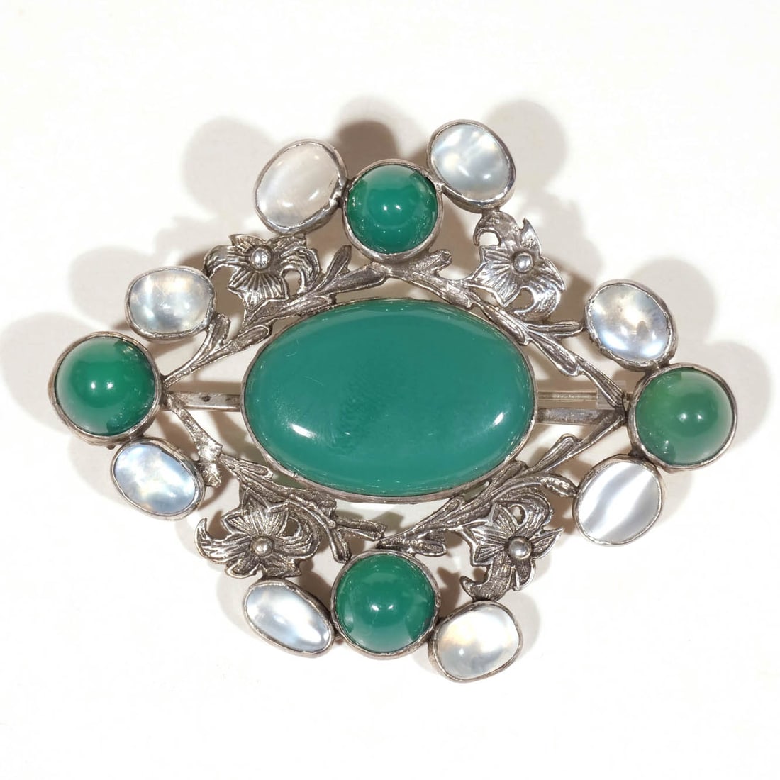 BRITISH ARTS & CRAFTS MOONSTONE & CHRYSOPRASE PIN: Set in sterling silver; 1 ozt h. 2-1/4 w. 3 in. Provenance: The Collection of Lynn and Bruce Heckman, noted contributors to the Metropolitan Museum of Art, New York