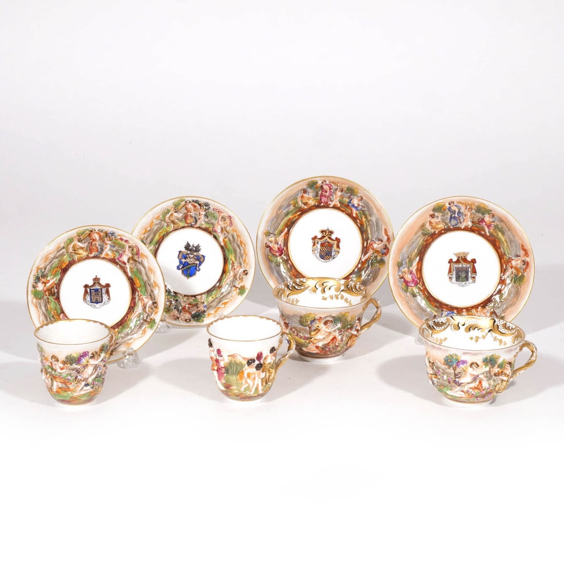 (4pc) NAPLESWARE (CAPODIMONTE): Two different size cups & saucers, saucers with heraldic device Provenance: Descent through the consignor's family [In Situ Item] This item will not be on display in our salesroom during our preview p