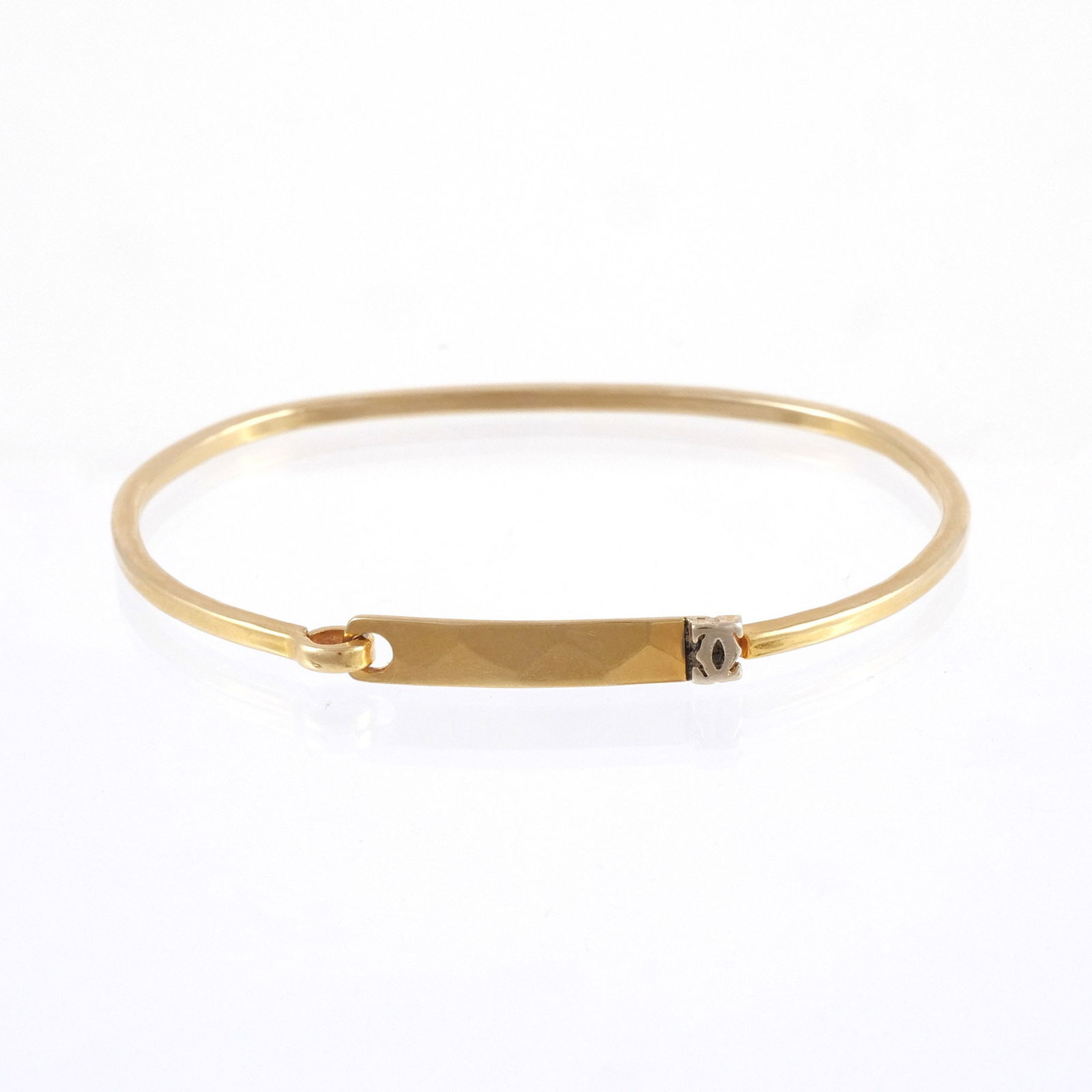 CARTIER 18K GOLD TENSION BANGLE: With a hammered bar clasp with opposing CC logo in relief, stamped '18K / Cartier', 6-3/4 in. interior circumference, 11 gms Provenance: Collection of an Upper East Side gentlewoman, New York, NY