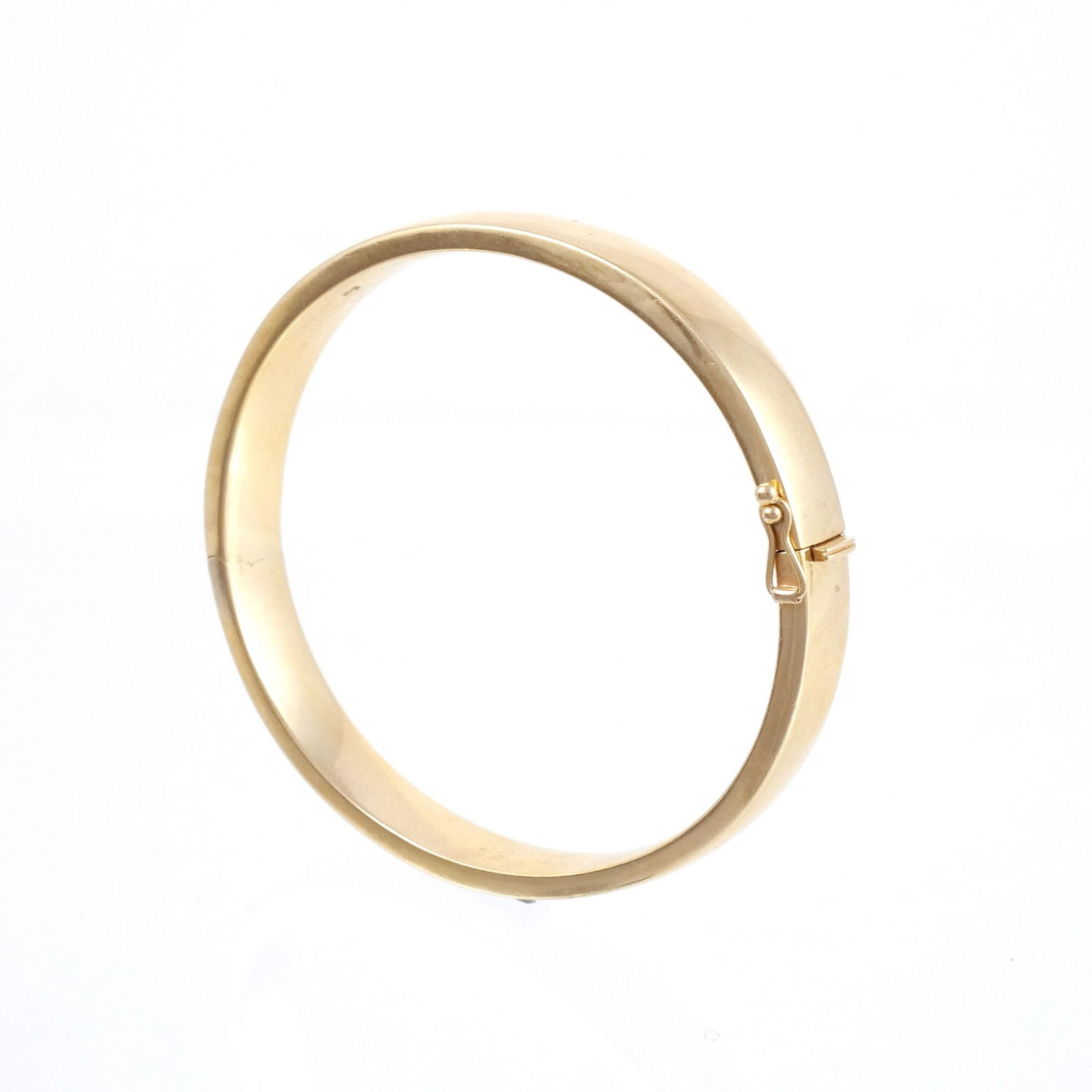 TIFFANY & CO. 18K ITALIAN GOLD HINGED BANGLE: Clasp tongue stamped 'Tiffany / Italy / 18K', 7 in. interior circumference, 16.5 grams Provenance: Collection of an Upper East Side gentlewoman, New York, NY