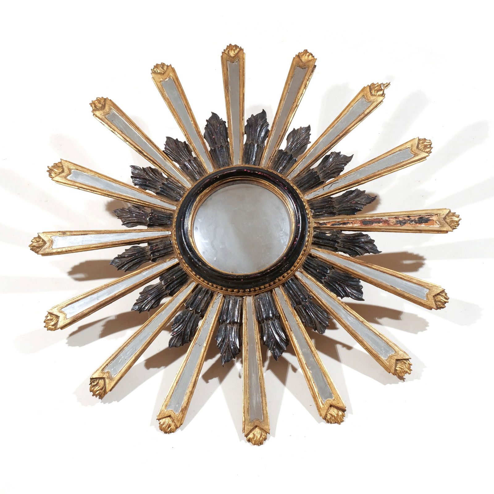 ITALIAN GILTWOOD SUNBURST MIRROR: 19th or early 20th century, carved and with ebonized details and glass panels, replaced central convex mirror dia. 35 in. Provenance: Descended through the family to the current owner, Scarsdale, NY [