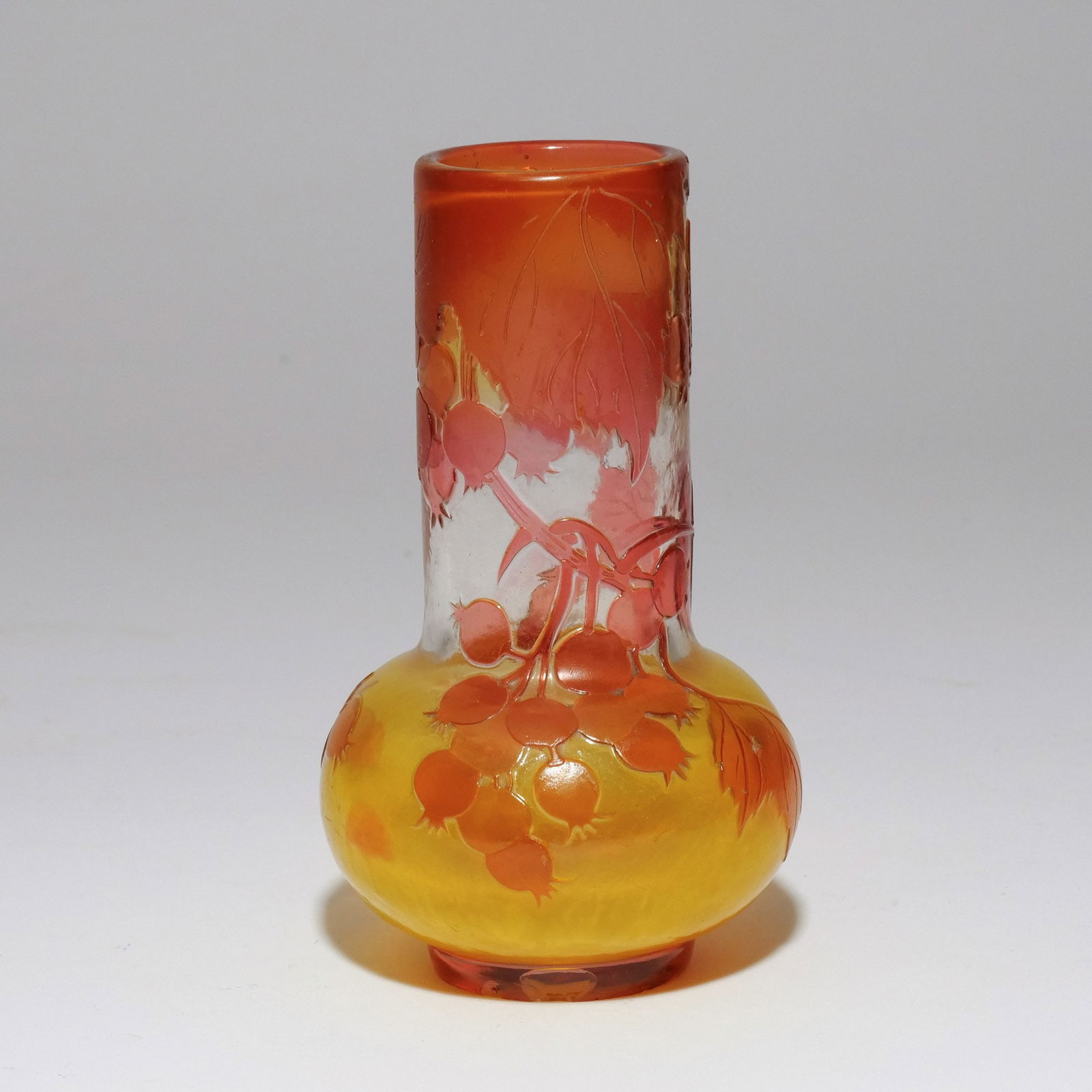 EMILE GALLÉ 'GROSEILLES ROUGES' VASE: Late 19th / early 20th century, acid-etched and fire-polished cameo glass of translucent, amber, and red hues, of bottle shape with cylindrical neck and bulbous base, having cameo decoration showing r