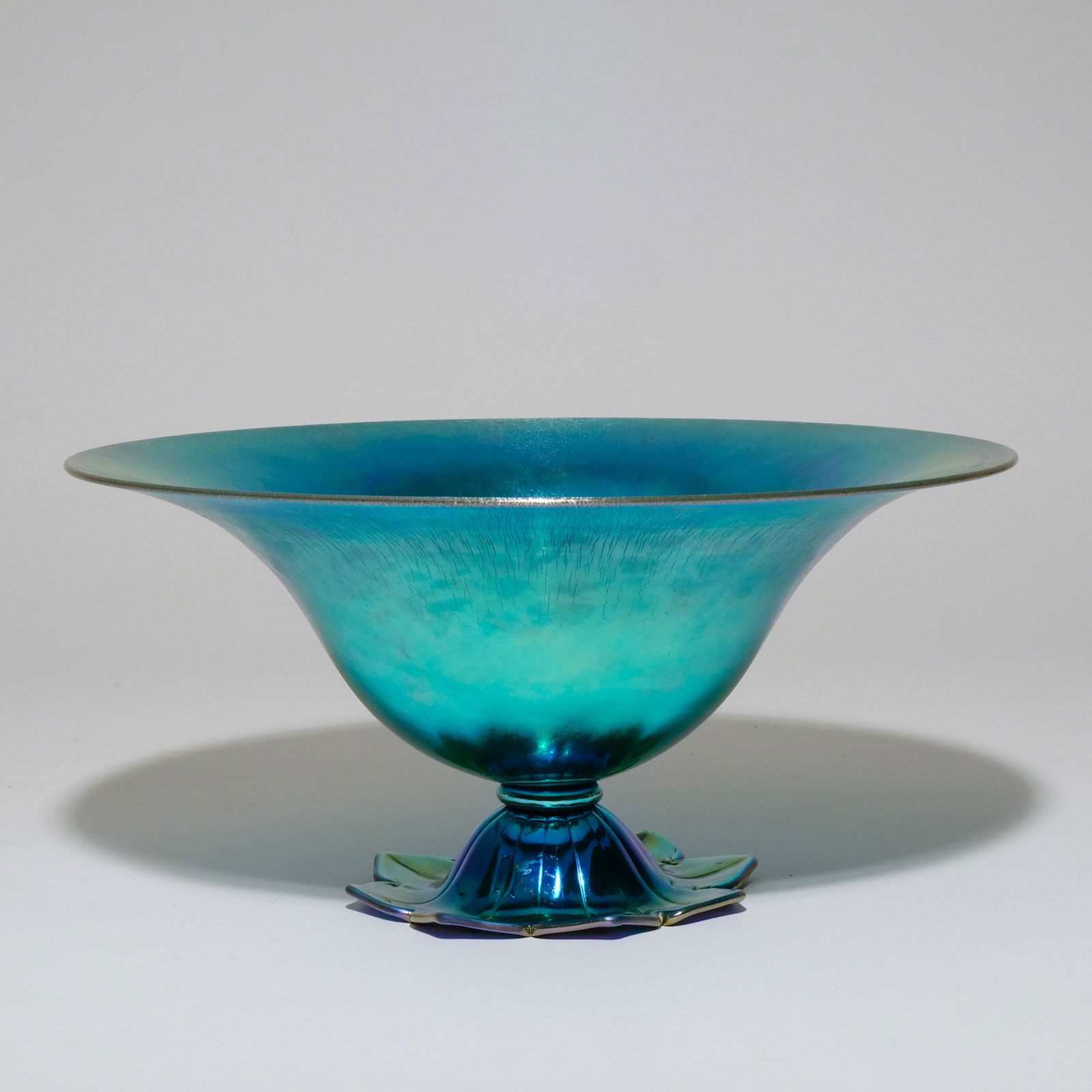 STEUBEN BLUE AURENE GLASS FOOTED BOWL: With foliate base, signed 'STEUBEN AURENE 6058' h. 5-5/8 dia. 12 in. Provenance: An Eastchester, NY estate