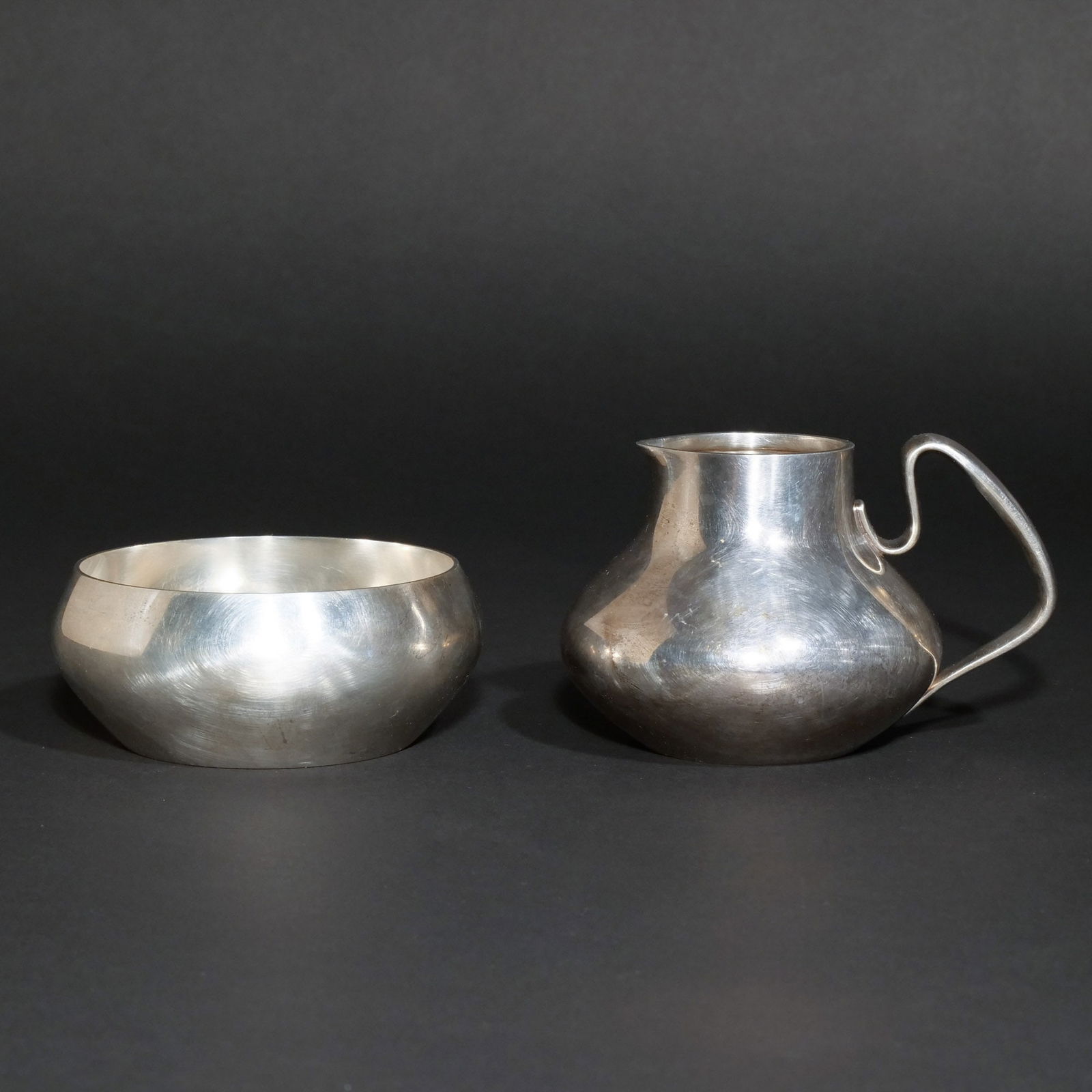 (2pc) GEORG JENSEN DESIGNED BY HENNING KOPPEL: Including a creamer and sugar bowl, C. 1952, pattern 1017, marked HK, Georg Jensen, sterling Denmark, Dessin, Total weight 14 ozt h. 2-3/4 w. 5 in. Provenance: A Central Park West estate, New York, NY