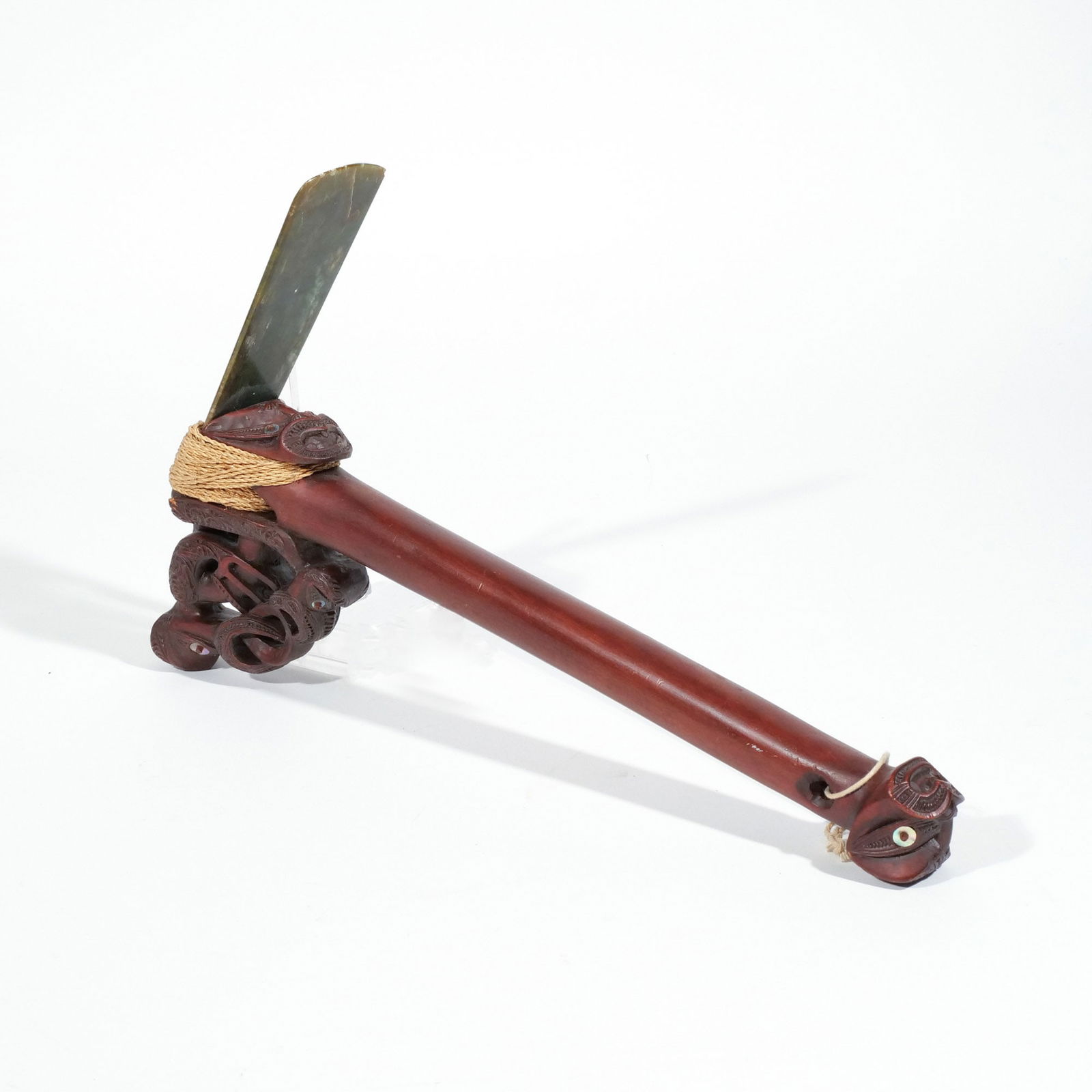 MAORI CEREMONIAL AXE WITH JADE BLADE: Mid 20th century, with intricately carved wooden handle and mother-of-pearl inlay h. 14-1/2 w. 9-3/4 in. Provenance: Descended through the family to the current owner, Scarsdale, NY [In Situ Item] Thi