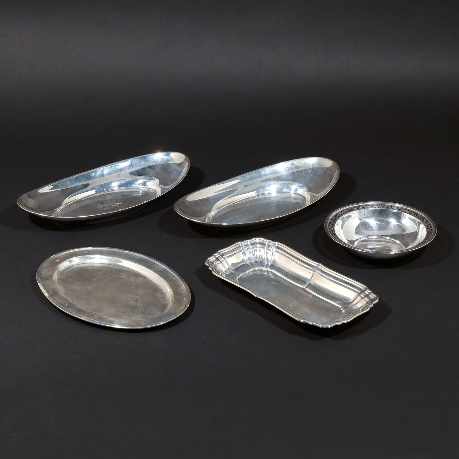 (5pc) MISC STERLING BREAD TRAYS AND OTHER: Including two oval bread trays by Gorham (one with monogram); one tray with scalloped rim by Gorham; an oval tray; and a Tiffany & Co. wine coaster; 34 ozt h. 2 w. 12 d. 6 in (largest) Provenance: A p