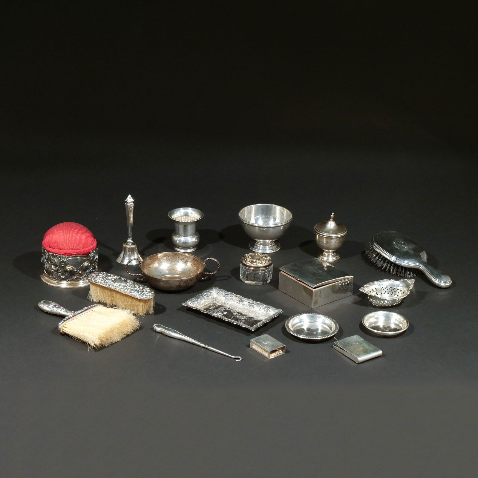 (18pc) MISC SILVER DRESSING ITEMS AND OTHER: Including 3 brushes; 2 egg cups; 1 small footed bowl; 1 dinner bell; 1 small double-handled bowl; 2 round ashtrays; 1 scalloped nut dish; 2 matchbox cases; 1 glass patch box with sterling lid; 1 sewin