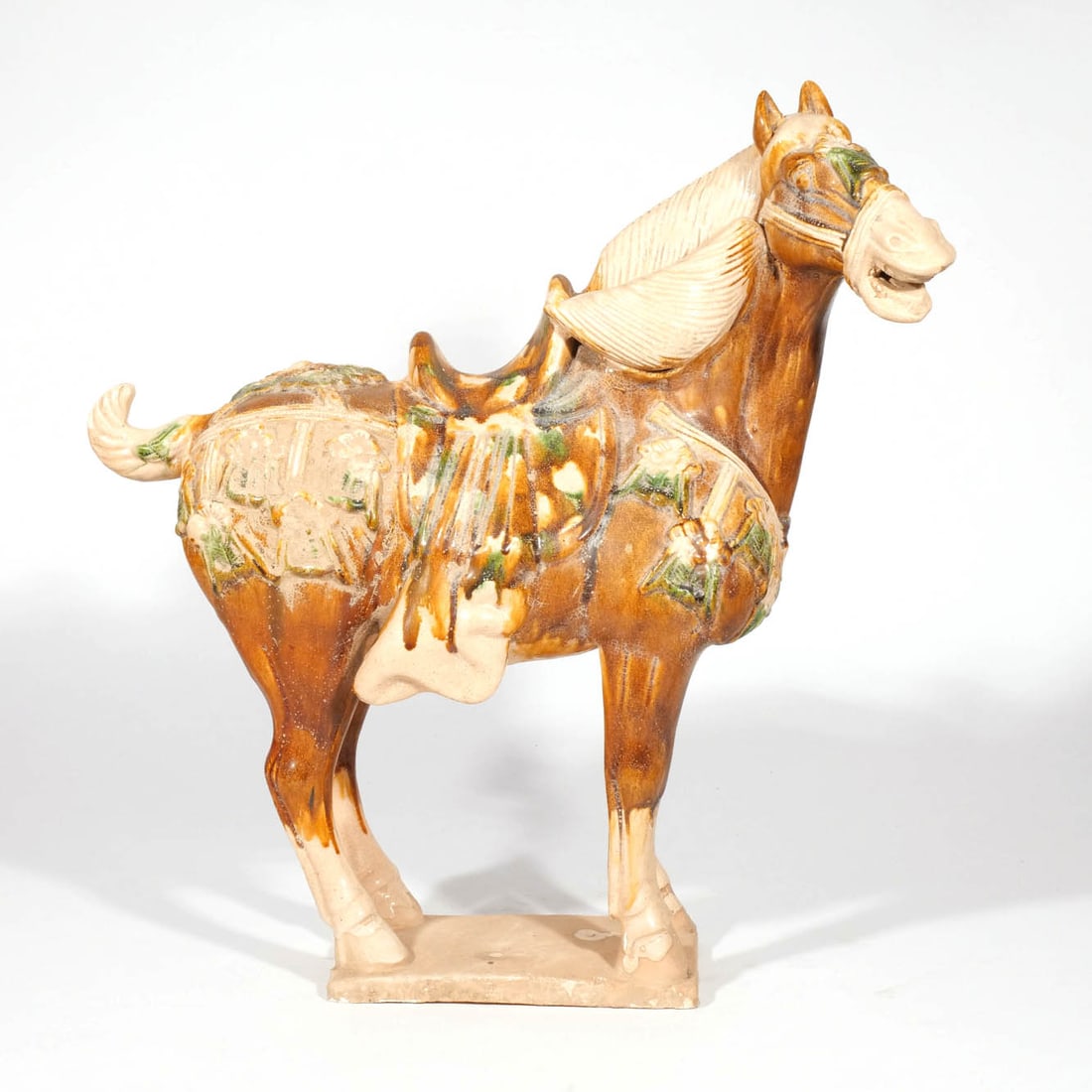 TANG-STYLE GLAZED CAPARISON HORSE: 20th century h. 19-1/2 w. 19 d. 8 in. Provenance: The estate of Leonard Ashley, noted Professor and Author on Geolinguistics and the Occult, Brooklyn, NY [In Situ Item] This item will not be on displa