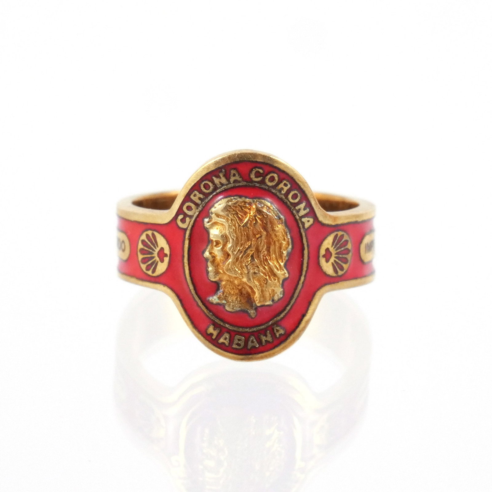 CARTIER 18K GOLD AND ENAMEL CIGAR BAND RING: With a central engraved gold profile, 'Corona / Habana / Importado', and flourishes within red enamel, marked '18k' and signed 'Cartier', size 8, 8.3 g total weight Provenance: Descent through a decea
