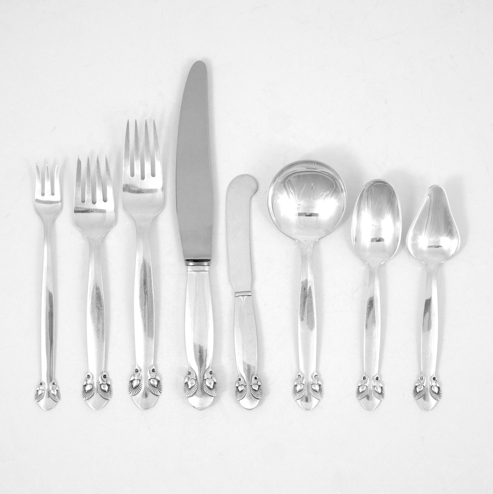 (100pc) GEORG JENSEN STERLING FLATWARE SERVICE: In the 'Bittersweet' pattern; including 12 dinner knives, 12 dinner forks, 12 salad forks, 12 cream soup spoons, 12 teaspoons, 12 citrus spoons, 12 olive forks, 12 butter knives, 1 carving fork, 2 ser