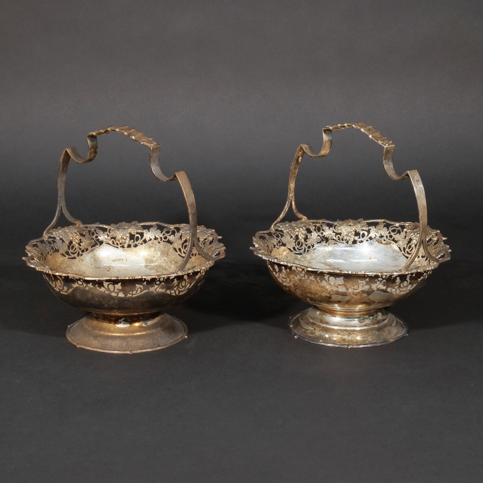 (2pc) ATKINS BROTHERS STERLING SILVER BASKETS: With open work raised and engraved grape leaf design, Sheffield, circa 1938, with Sheffield hallmarks and Atkins Brothers maker's mark ('HA' for Henry Atkin), 44 ozt total weight h. 9-1/2 in. dia. 8-1