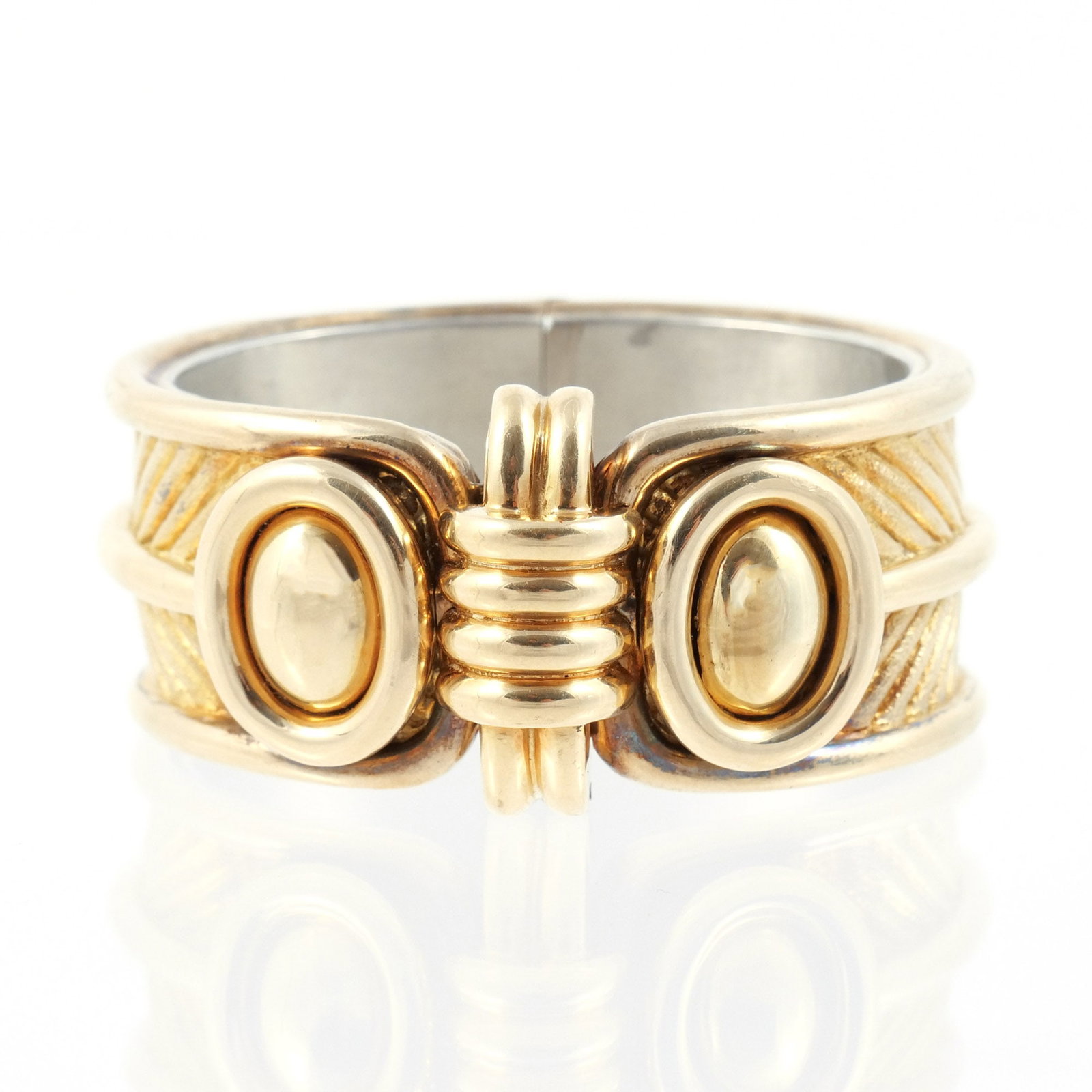 14K GOLD AND SILVER-BACKED HARD BRACELET: Composed of gold exterior with polished oval bosses and textured panels over sterling silver core, unmarked but exterior tests as 14k and interior tests as sterling silver, 6-1/4 in. interior