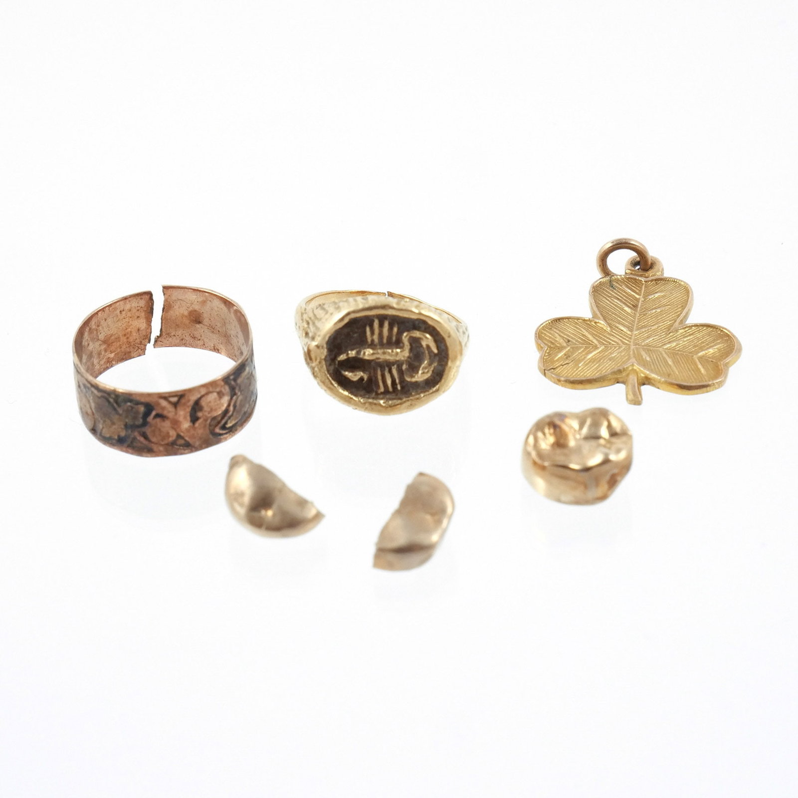 (6pc) MISC. GOLD ITEMS: Including an 18k gold scorpio ring (broken at back), size 4-1/2; 3 dental gold fragments; a 10k gold band (broken at back), size 6-3/4; and a 9k gold shamrock pendant; 15.8 g total weight h. 1 in. (la