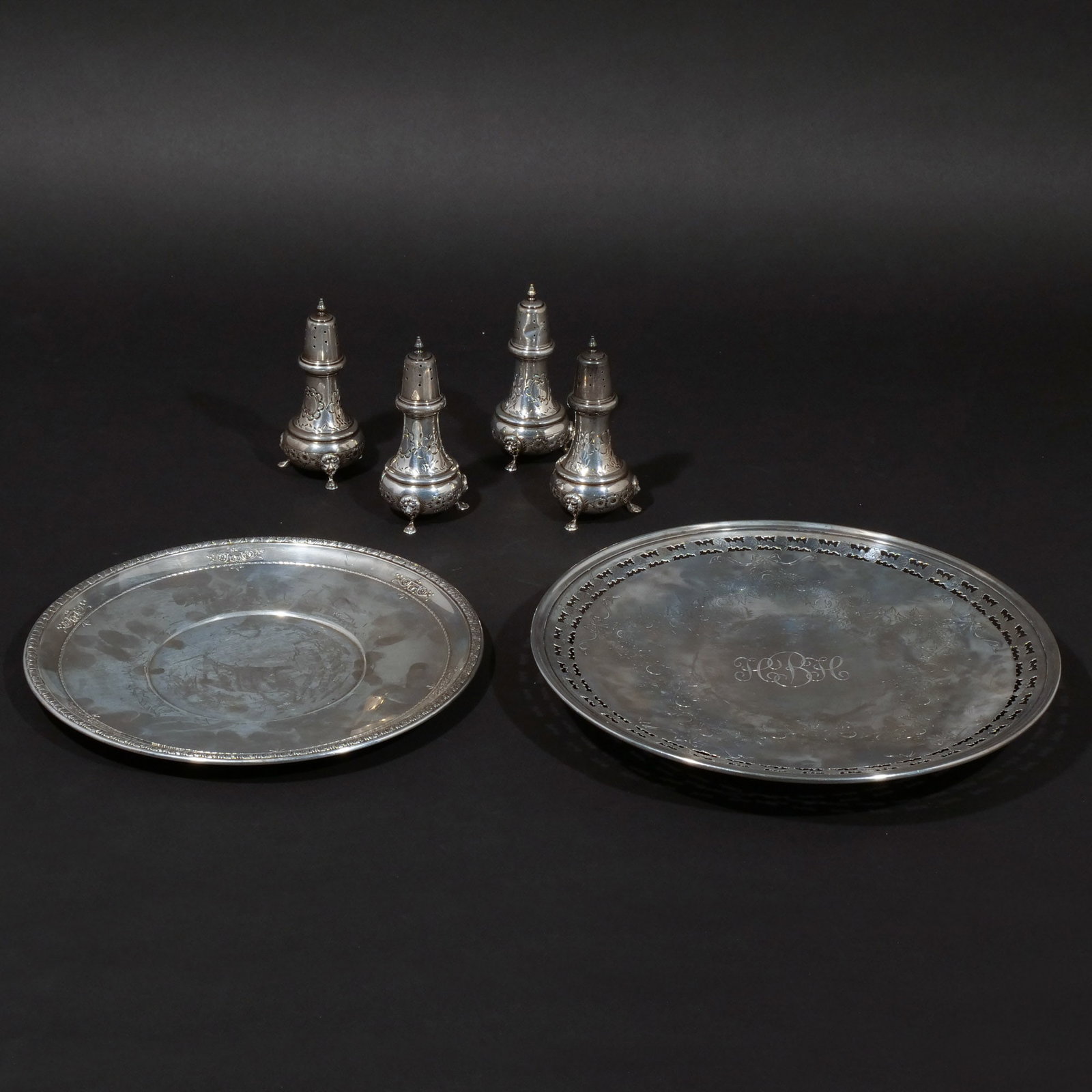 (6pc) STERLING SILVER SALT SHAKERS AND PLATES: Including a set of 4 footed salt shakers with engraved floral motif, monogrammed; a Wallace underplate with raised floral border and motif; and a pierced footed platter with etched foliate motif,