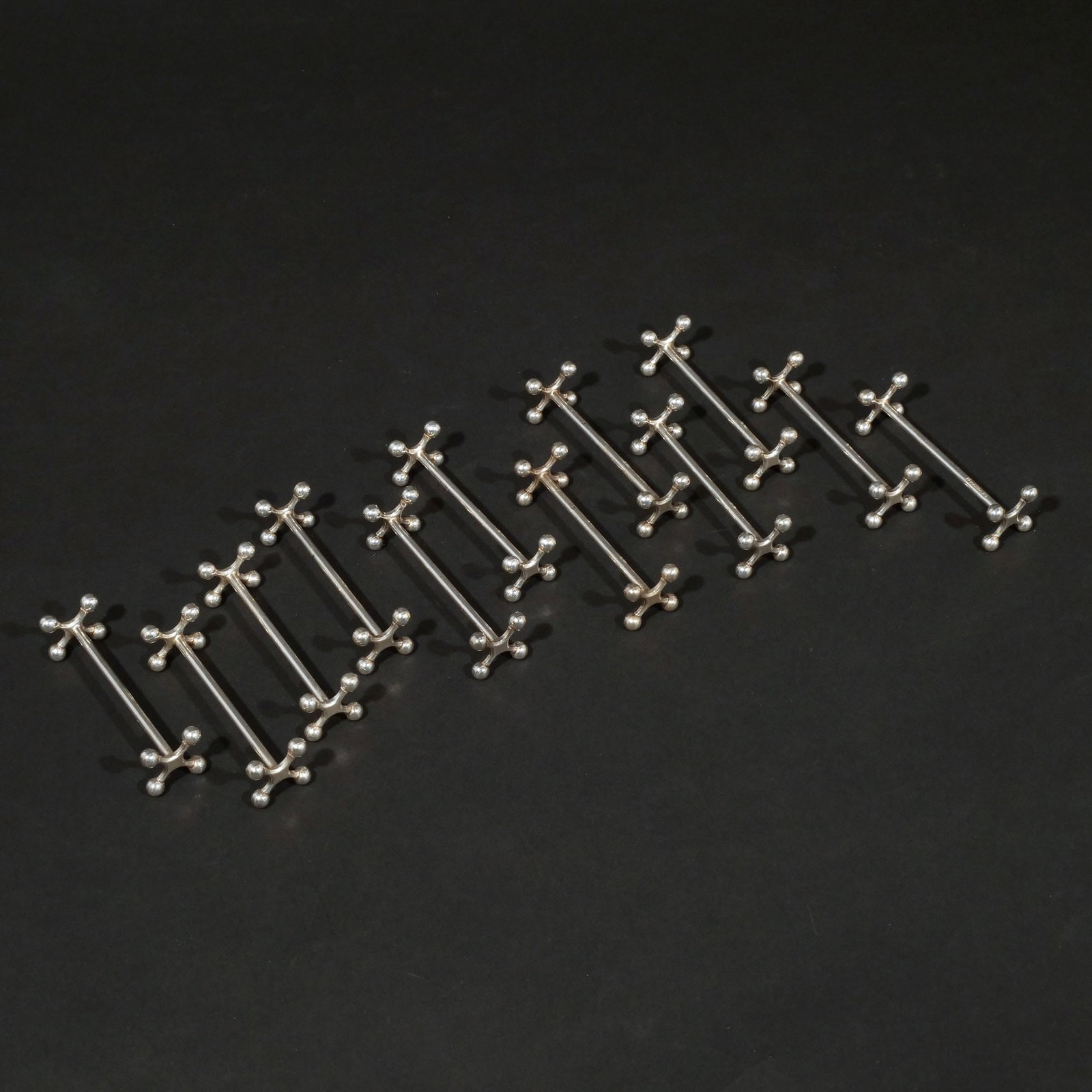 (12pc) SET OF CHRISTOFLE SILVERPLATE KNIFE RESTS: with ball feet, marked Christofle h. 1 w. 3-1/2 in. Provenance: Descent through a prominent Manhattanite's estate [In Situ Item] This item will not be on display in our saleroom during the preview