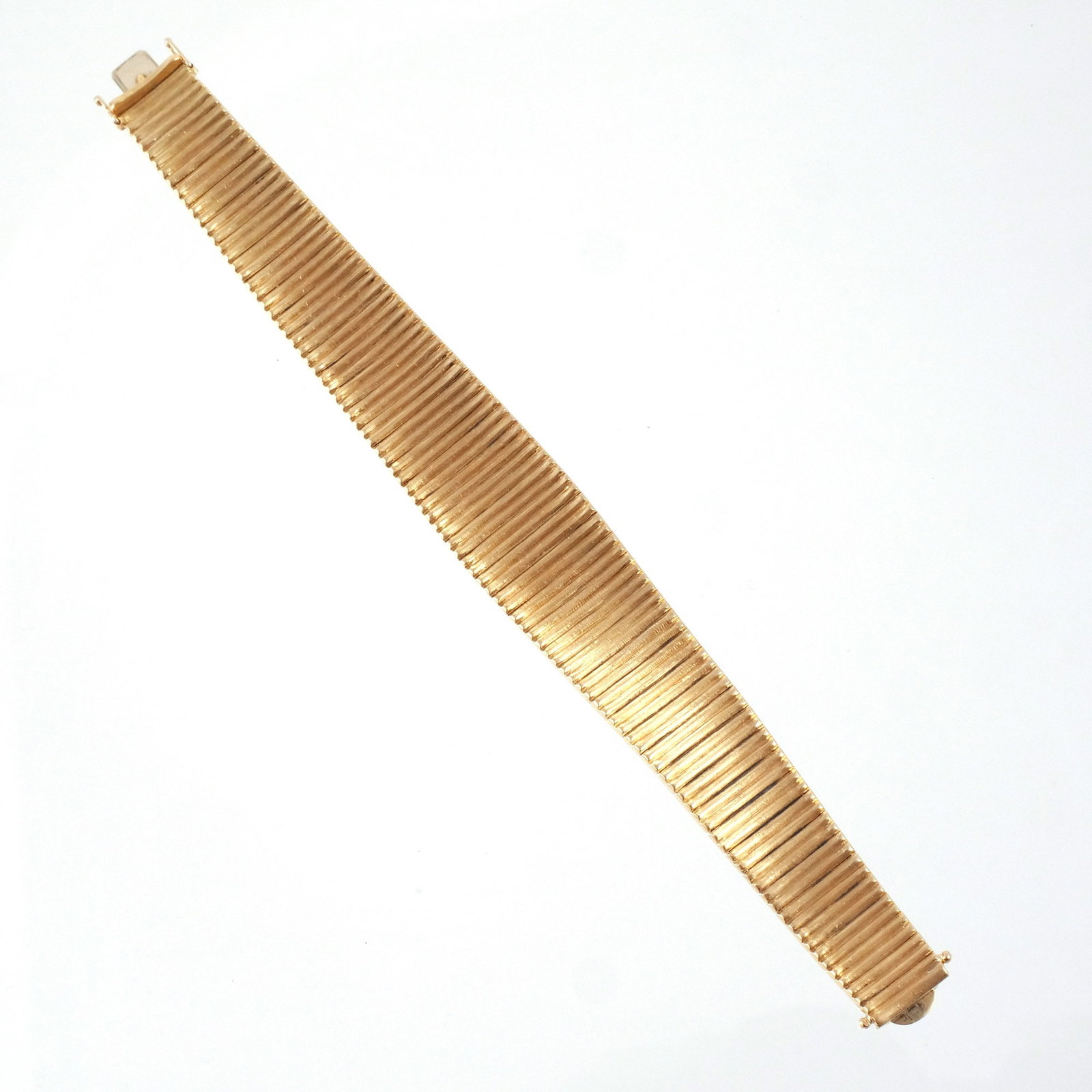 18K ITALIAN GOLD FLEXIBLE BAND BRACELET: Textured matte gold with smooth reverse, marked '750' and with obscured Italian registration mark, l. 7-1/2 in., 66 g w. 5/8 in. (widest point) Provenance: The estate of a noted architect and biblioph