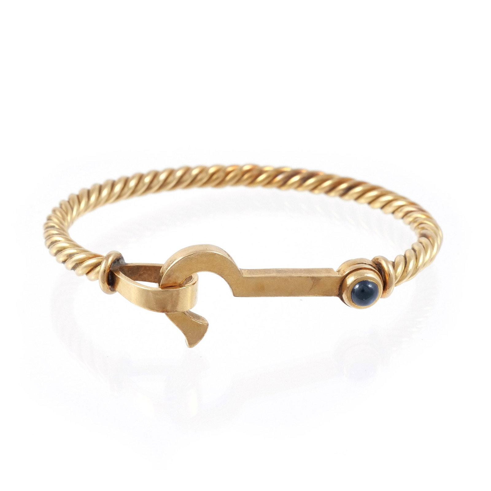 18K GOLD TENSION BANGLE: Twisted rope design with blue cabochon terminal and hook-form closure, marked '750', 6 in. interior circumference, 34 g total weight