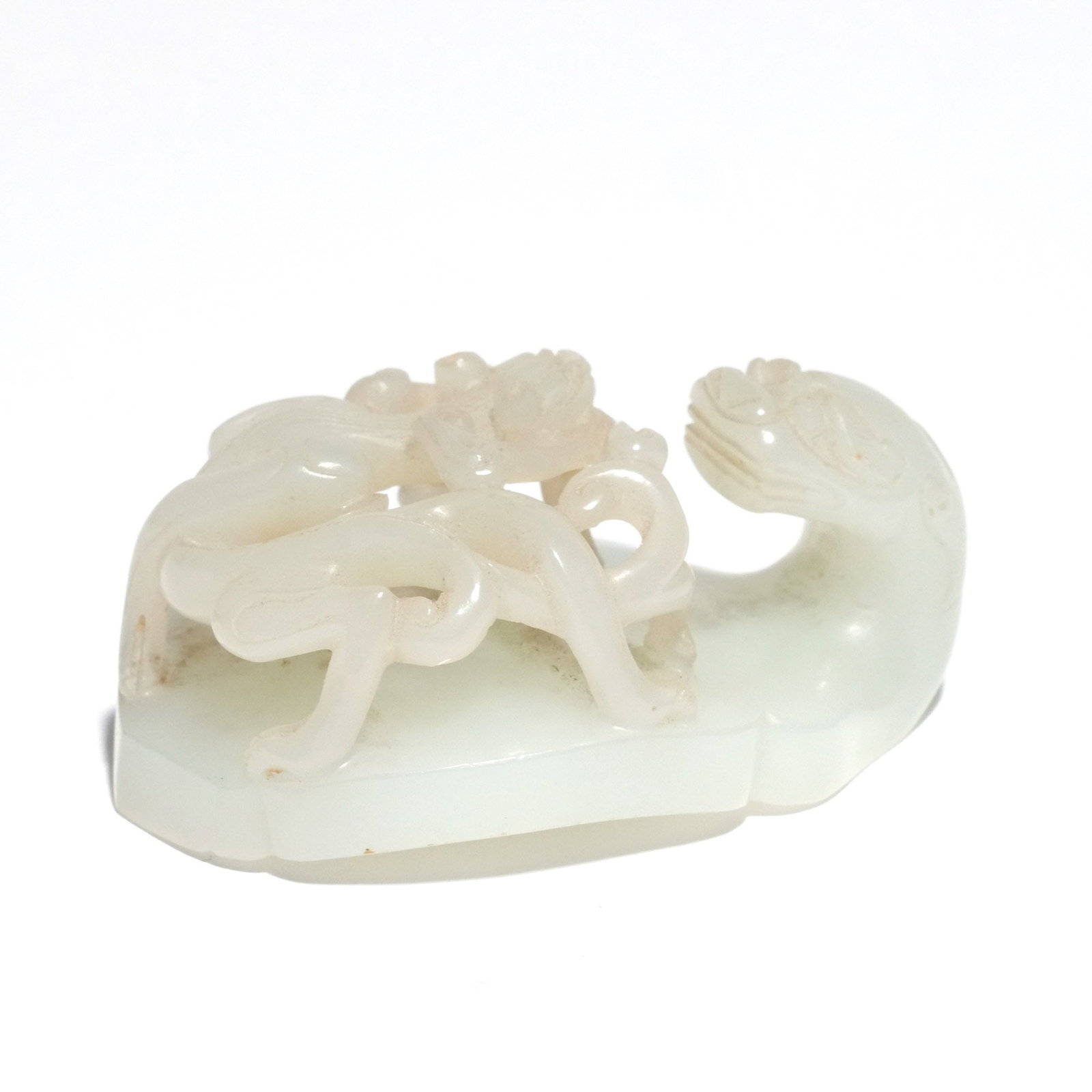 CHINESE PALE CELADON JADE BELT HOOK: Late Qing dynasty, 19th century, with reticulated dragonet and lingzhi scrollwork h. 1 w. 2-1/2 d. 1-3/4 in. Provenance: The estate of Richard and Jean M. Bergstresser, owner of the Laurence McGuire H