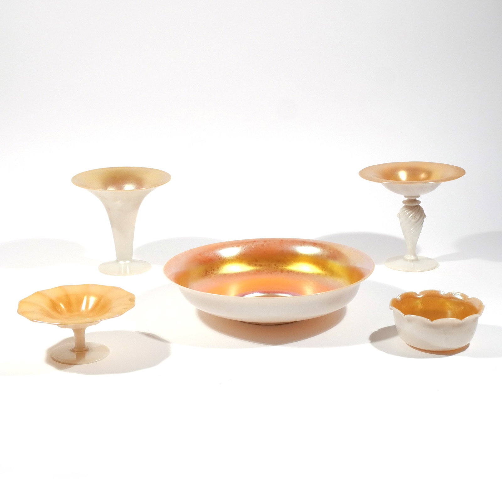 (5pc) STEUBEN CALCITE AND GOLD AURENE: Including a large bowl / underplate, a foliate bowl, two compotes, and 1 trumpet vase h. 6-1/4 in. (tallest) dia. 12 in. (large bowl) Provenance: Descent through a prominent Greenwich, CT doctor's