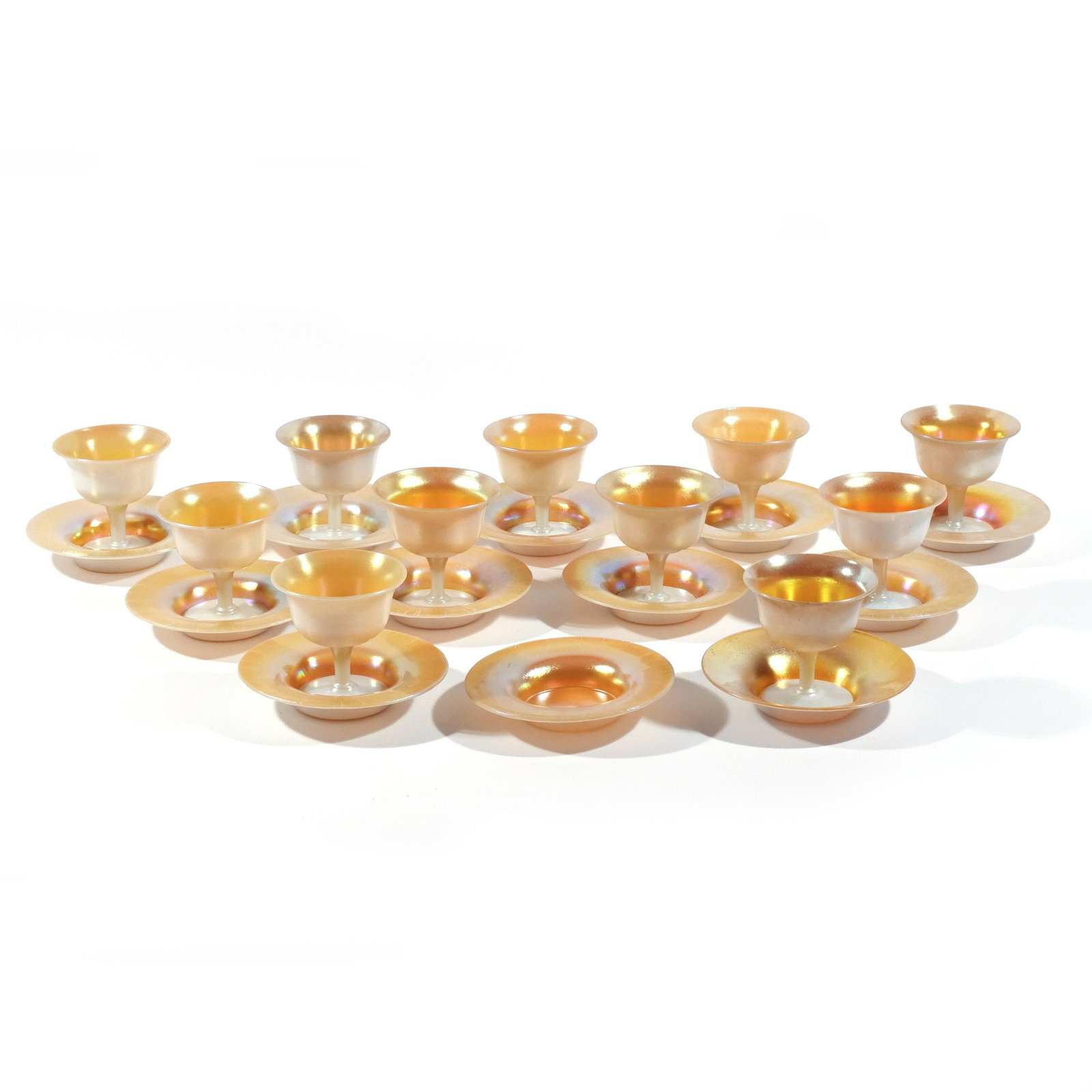 (23pc) STEUBEN CALCITE & GOLD AURENE GLASS: Comprising 10 matching sherbet cups with 11 saucers, plus 1 similar cup with saucer h. 4 in. (cups) dia. 6-1/4 in. (saucers) Provenance: Descent through a prominent Greenwich, CT doctor's estate [In S