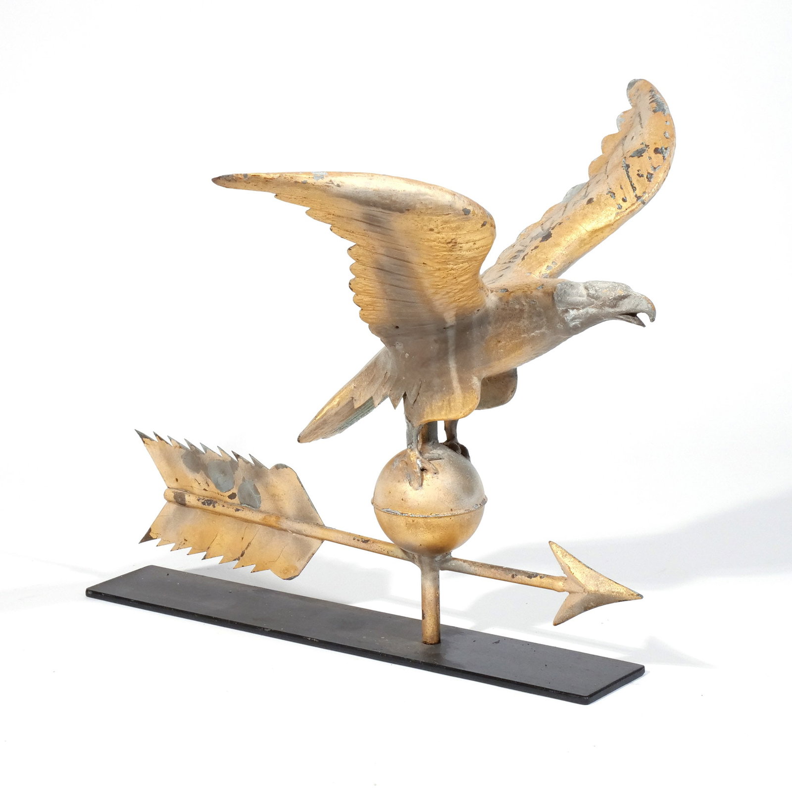 FULL-BODIED GILT EAGLE WEATHERVANE: Copper with gilt finish, zinc head, the eagle shown with spread wings above a ball and arrow directional h. 18 w. 18 d. 14-1/2 in. overall: 19 x 18 x 14-1/2 in. (with stand) Provenance: Private collec
