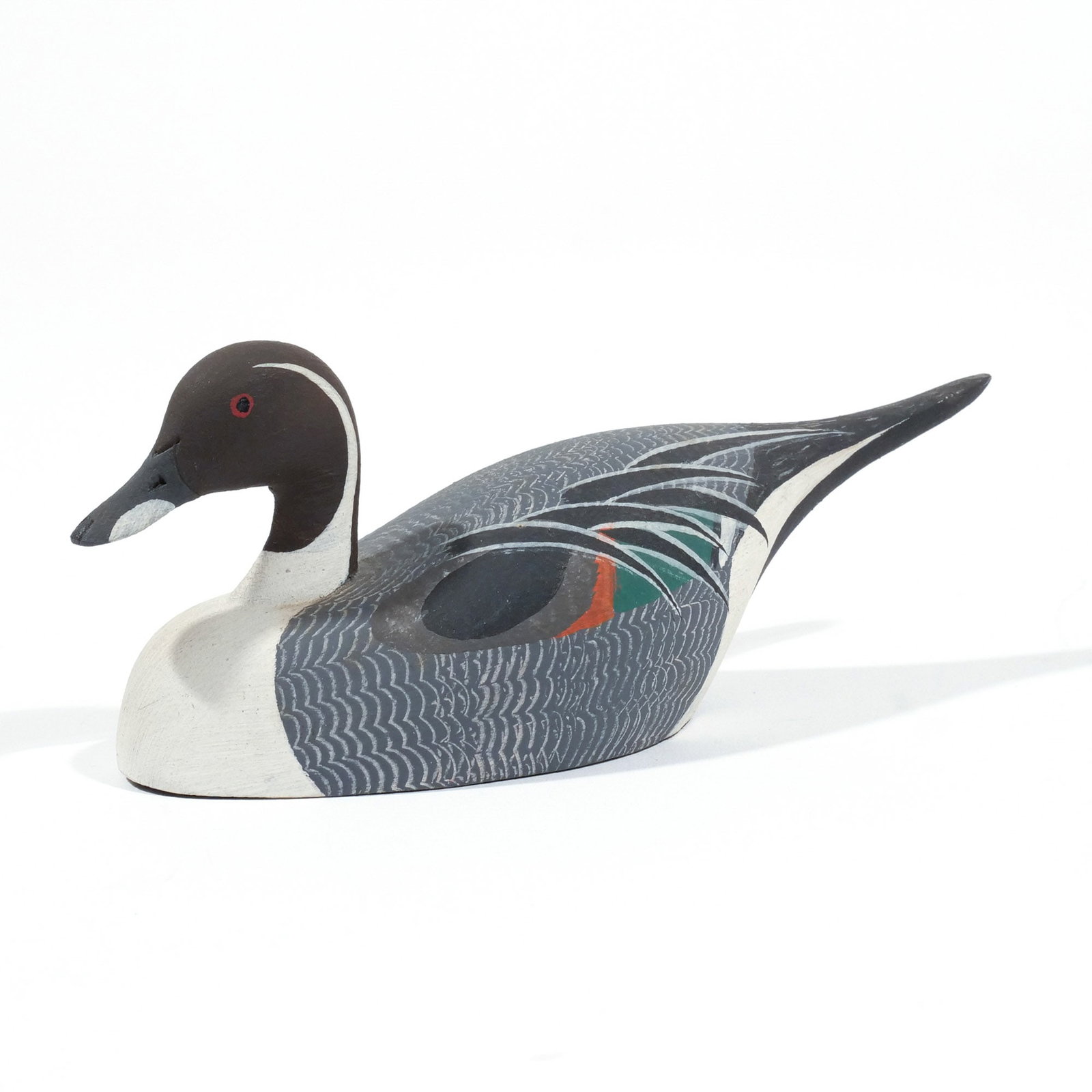 KEN HARRIS CARVED MINIATURE PINTAIL DRAKE: Stamped 'Made by / 'Ken' Harris / Woodville, N.Y.' on underside h. 2-1/2 w. 6-1/2 d. 2-3/4 in. Provenance: Descended through the estate of U.S. Ambassador James C. H. Bonbright, Washington, DC