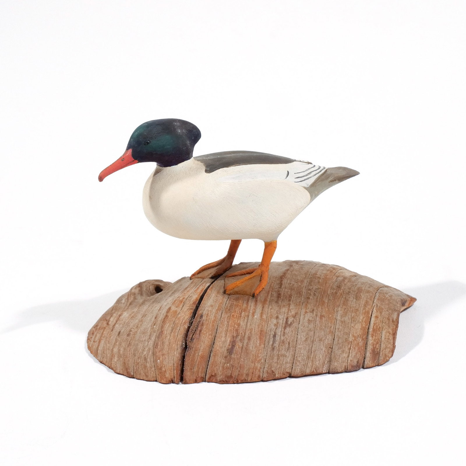 HAROLD GIBBS (1886-1970) COMMON MERGANSER: Carved miniature, mounted on a driftwood base, signed with conjoined 'HNG' on underside h. 2-5/8 w. 4 d. 2-3/4 in. (overall) Provenance: Descended through the estate of U.S. Ambassador James C. H. Bon