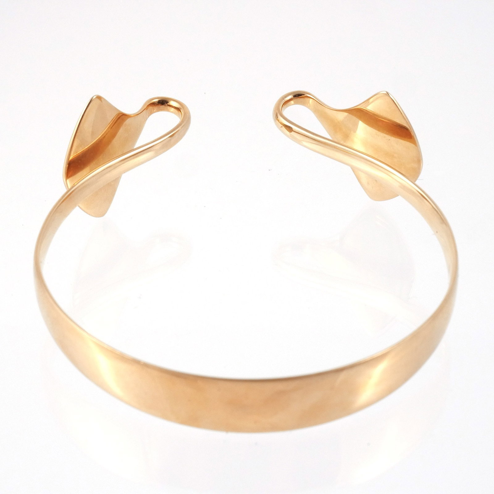 HANS HANSEN 14K GOLD CUFF: Model 210 with curved fan-shaped terminals, interior signed 'Hans Hansen' and marked '585 / Denmark / 210', 7-3/4 in. interior circumference, w. 1/2 in. at center, 1 in. at terminals, 38.4 g Provenanc