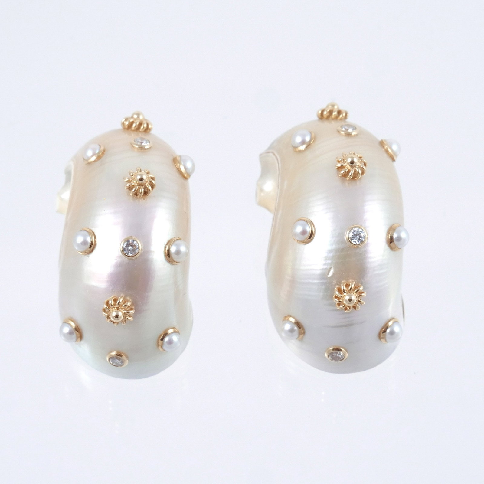 PAIR of TRIANON-STYLE SHELL FORM EAR CLIPS: Half shells accented by 14k gold bezel set seed pearls, diamonds, and gold bosses, marked '14K' with engraved number 'T8640B', 21 g total weight h. 1-1/2 w. 11/16 in. Provenance: Descended through the