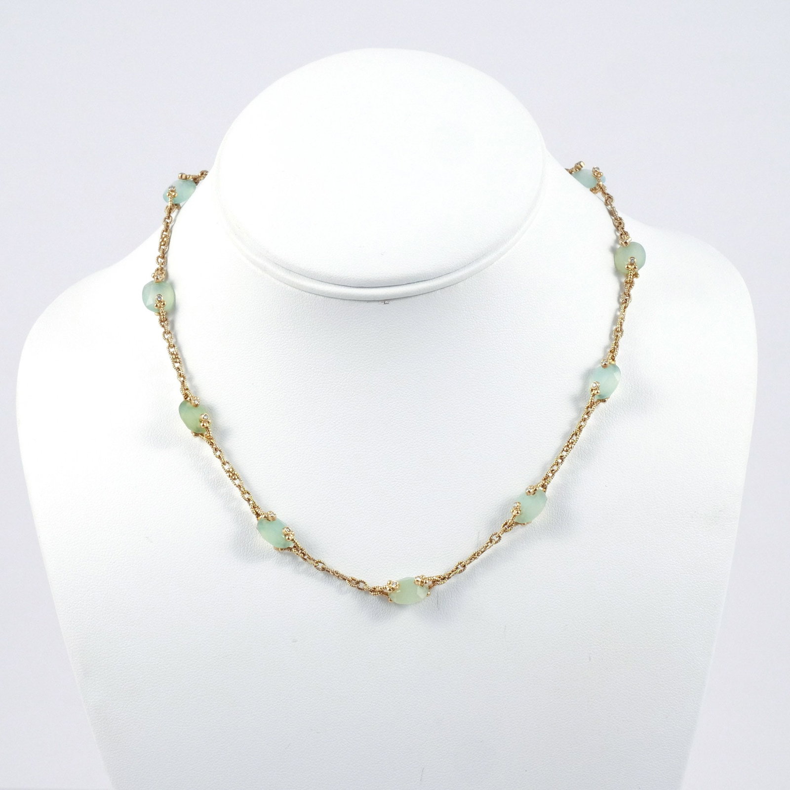 JUDITH RIPKA 18K GOLD & GEMSTONE STATION NECKLACE: Textured link chain with pale green oval faceted stations, likely chalcedony, each measuring 8 x 10 mm and pierced and held by gold beaded mounts with bezel-set round diamonds accents, signed 'J R' an