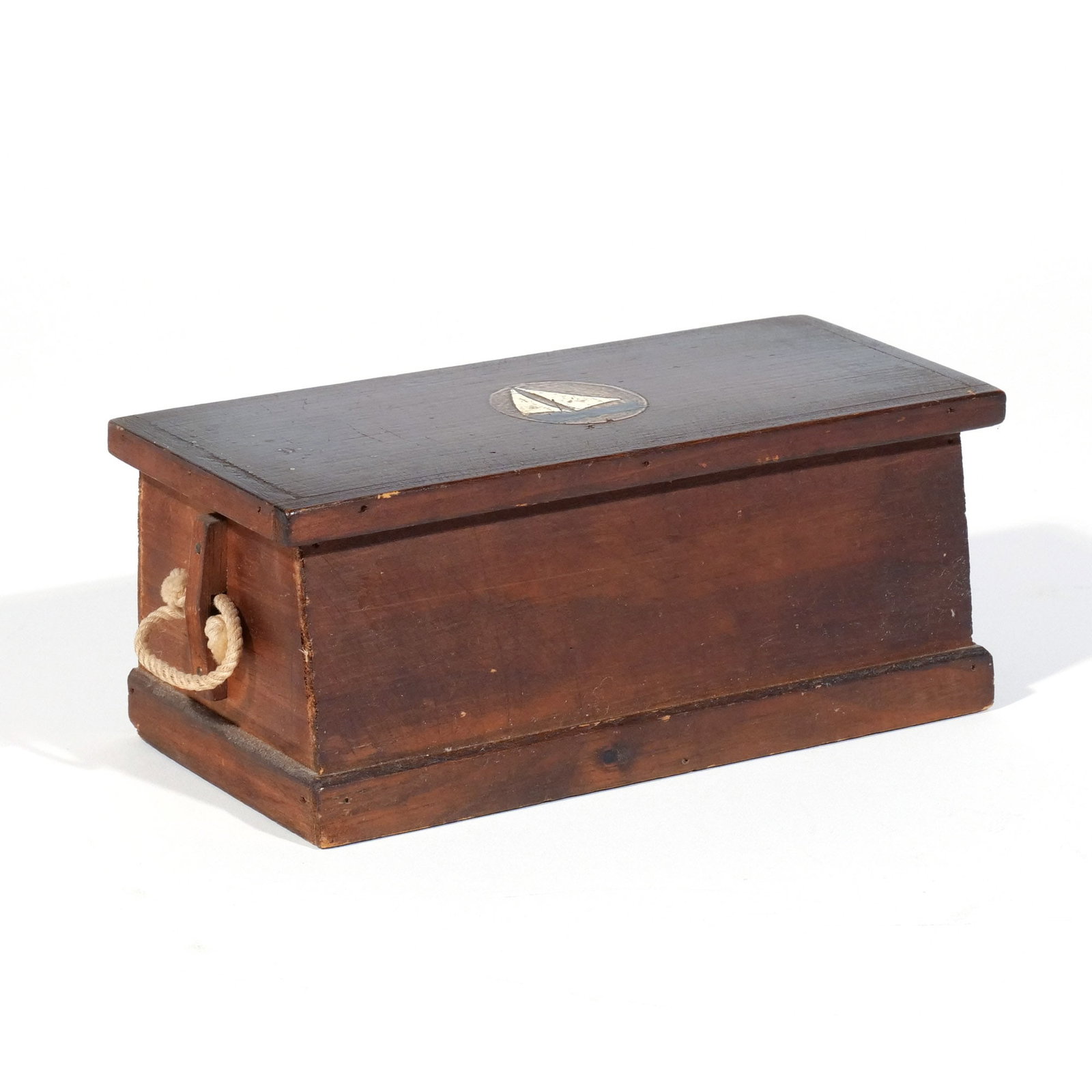 EARLY NAUTICAL BOXED DOMINOES SET: Late 19th century, the box in the shape of a sailor's chest, with a painted sailboat on the lid, housing a set of bone double-six dominoes h. 3-1/4 w. 8 d. 3-1/2 in. Provenance: Private collection,